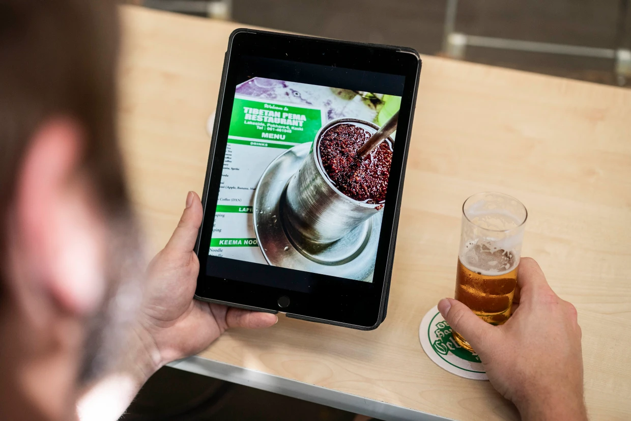 Sebastian Sauer zeigt eine Aufnahme mit Hirsebier von seiner Afrikareise.