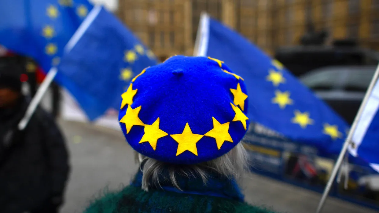 Eine Person demonstriert mit der europäischen Flagge vor dem britischen Parlament in London.