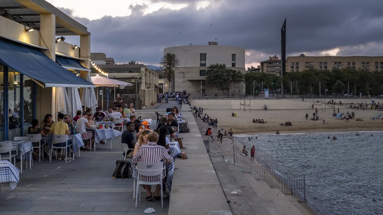 Einige Kunden eines Restaurants sitzen auf einer Terrasse in Barcelona.