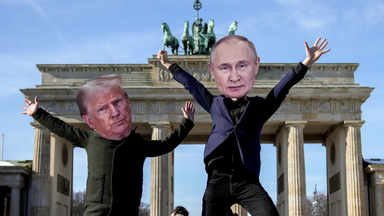 Demonstranten posieren vor dem Brandenburger Tor, an dem auch die amerikanische Botschaft liegt, als Trump und Putin