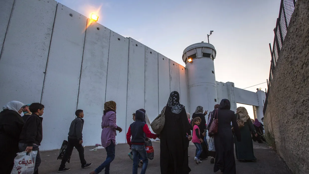 Im Schatten der Mauer: Palästinensische Frauen und Kinder gehen in Bethlehem am israelischen Schutzwall entlang.