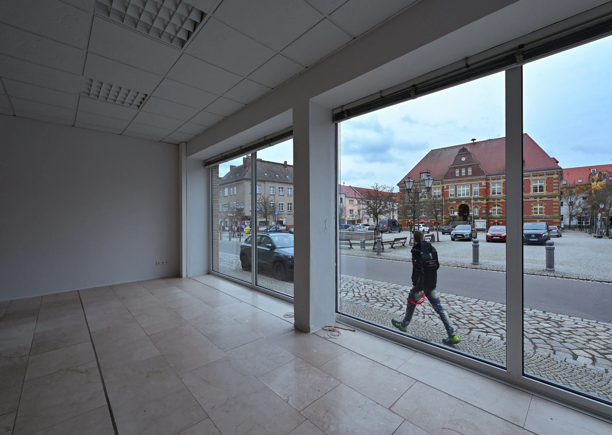 Blick aus einem leeren Ladengeschäft auf den Marktplatz von Calau