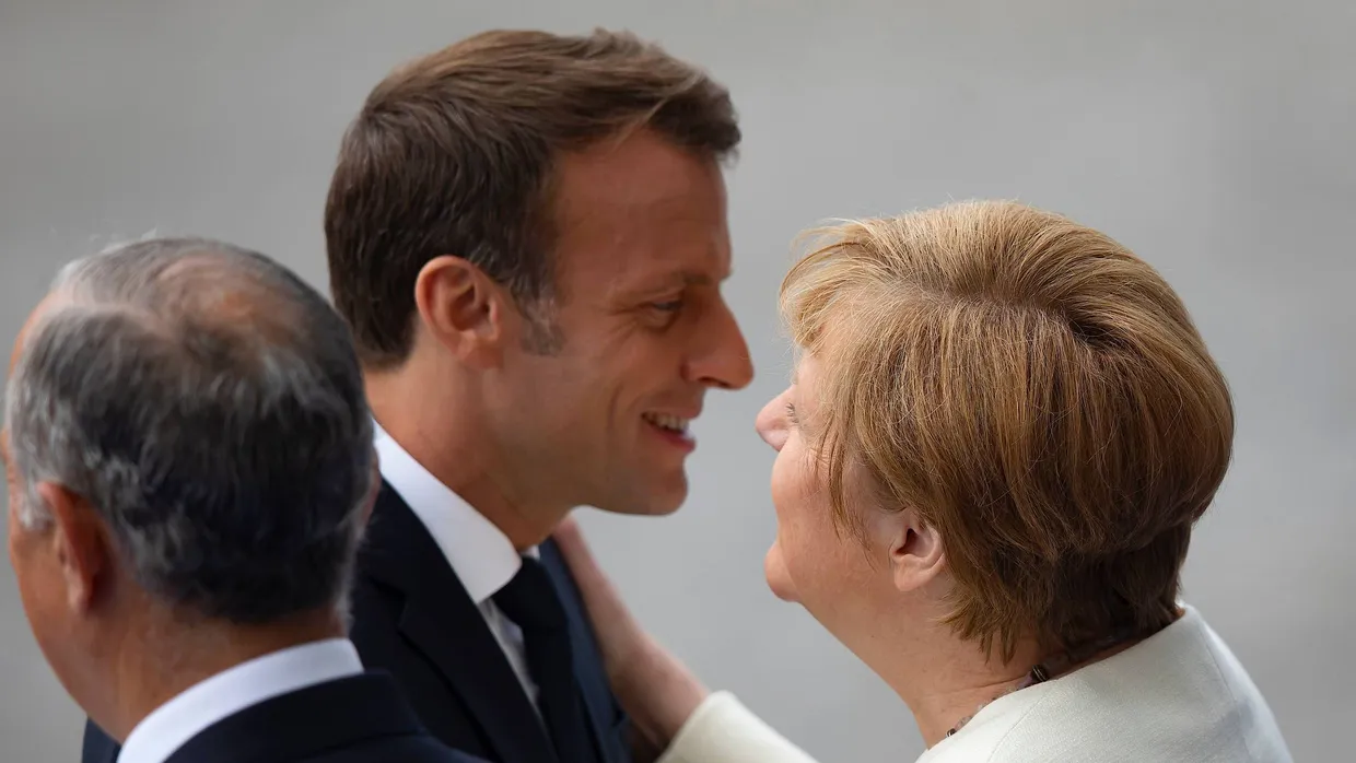 Merkel und Macron begrüßen sich bei den Feierlichkeiten zum französischen Nationalfeiertag.