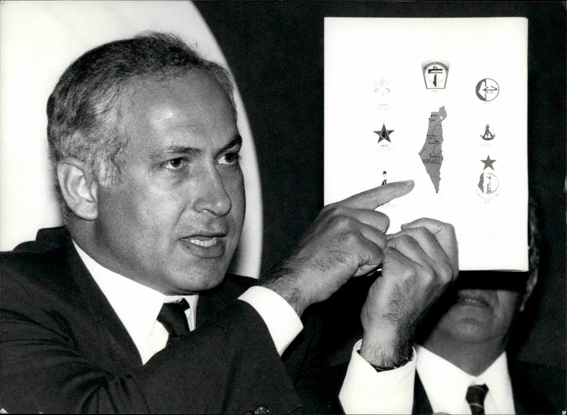 Netanjahu im Jahr 1990 als stellvertretender Außenminister bei einer Dringlichkeitssitzung des UN-Sicherheitsrats in Genf. Er zeigt eine Karte Israels, auf der die verschiedenen Mitglieder der Palästinensischen Organisation verzeichnet sind, die das israelische Territorium bedrohen.