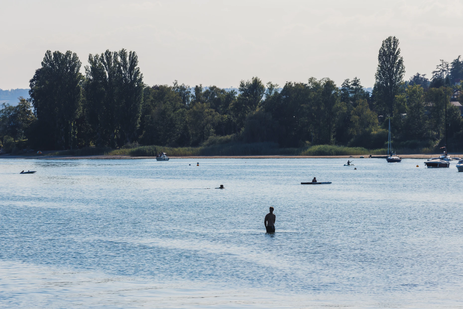 Ein Mann steht nahe dem Fähranleger in hüfthohem Wasser.