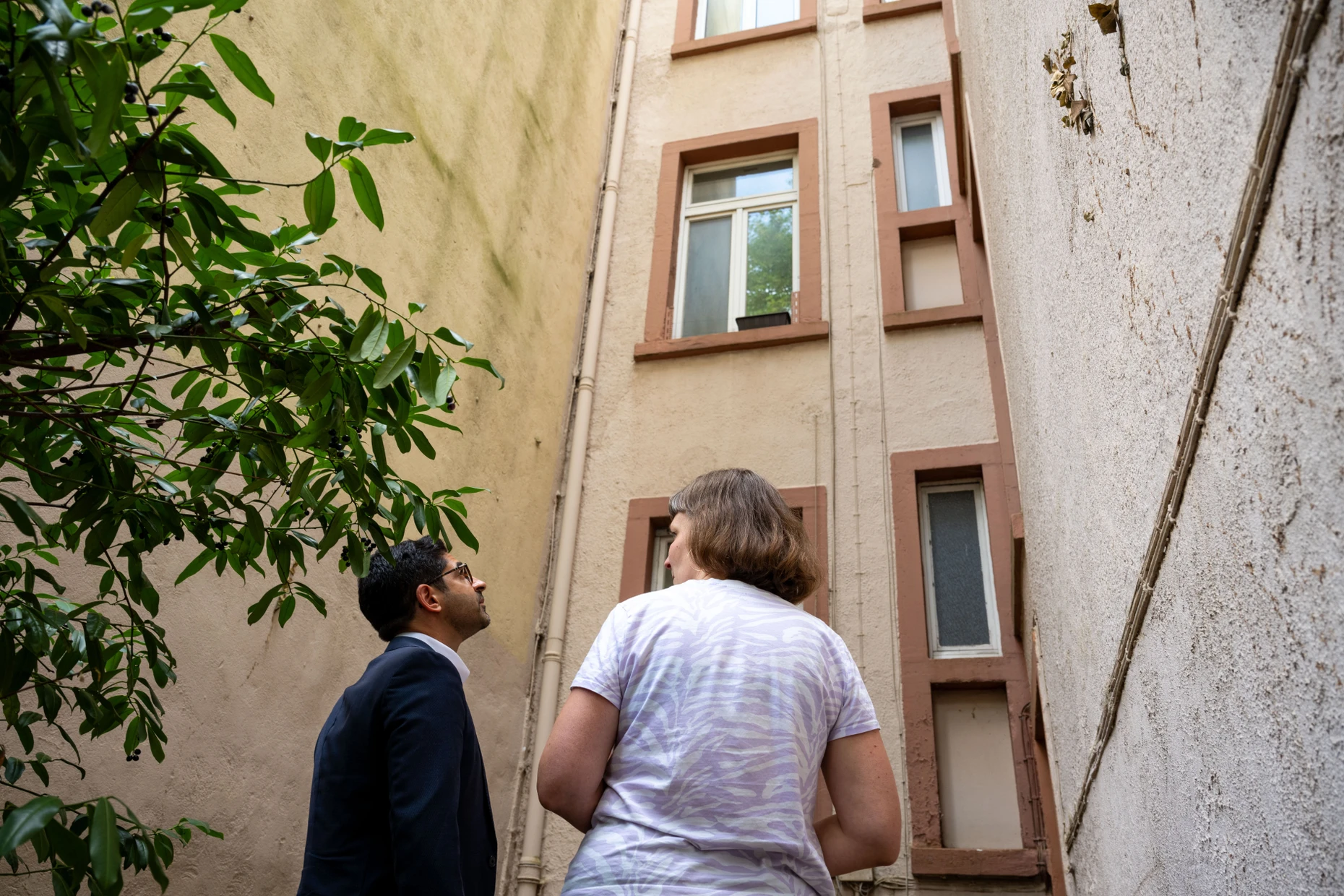 Hier könnte ein Aufzug gebaut werden: Beate Steinbach vom Vorstand der Dachgenossenschaft zeigt Wohnungsbauminister Kaweh Mansoori (SPD) das renovierungsbedürftige Haus an der Wittelsbacherallee.