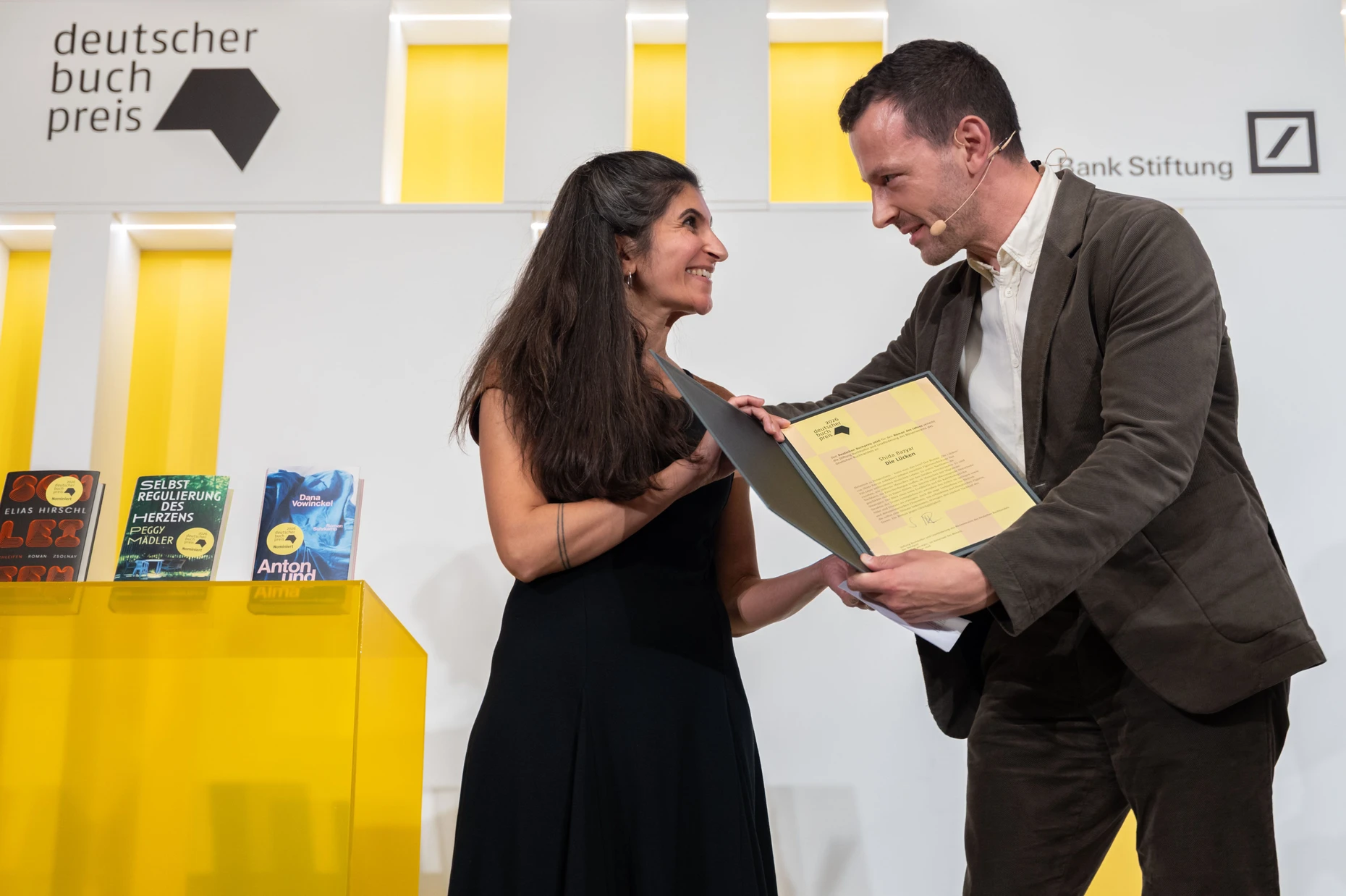 Shida Bazyar nimmt die Urkunde von dem Vorsteher des Börsenvereins, Sebastian Guggolz, entgegen.