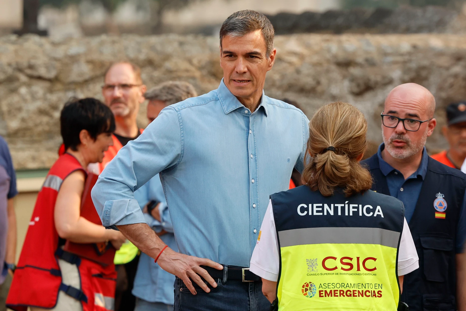 Spaniens Ministerpräsident Pedro Sanchez (links) im Gespräch mit Einsatzkräften im Dorf Cenicientos bei Madrid
