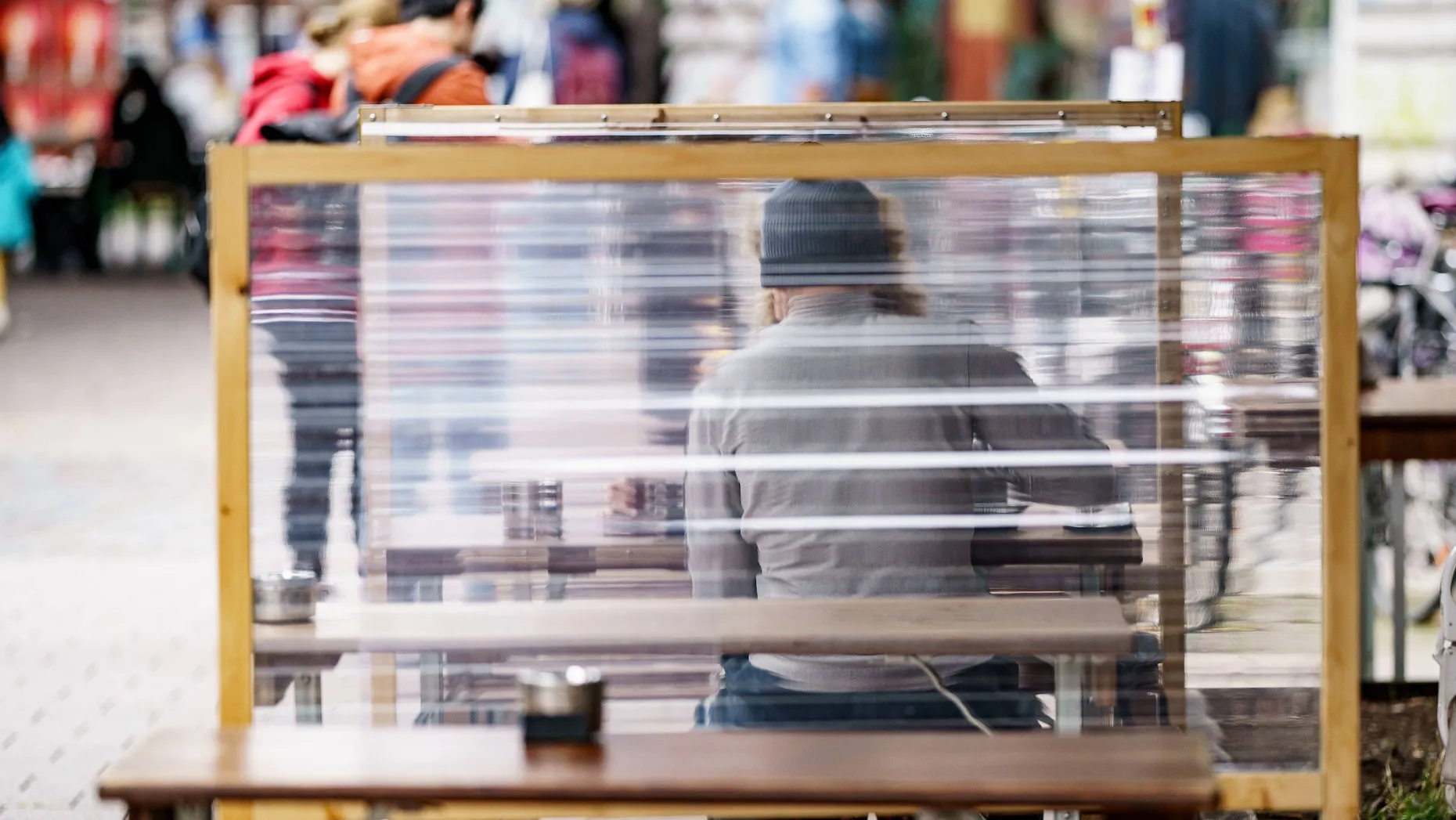 Gäste eines Hamburger Restaurants zwischen Plexiglas-Trennscheiben