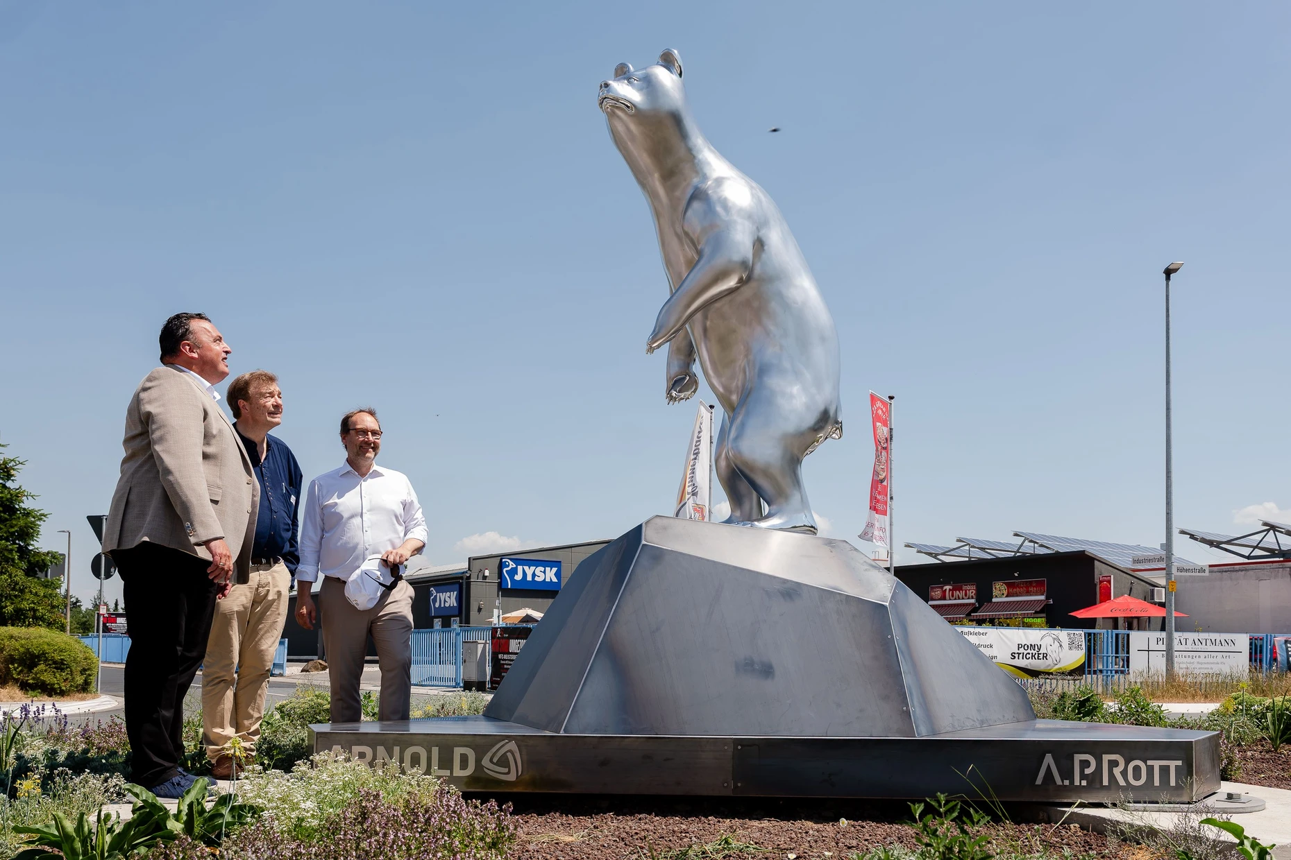 Neues Wahrzeichen: Arnold-Vorstand Boris Bachmeier, der Künstler A. P. Rott und Bürgermeister Lars Keitel (Grüne) bei der Enthüllung von Rotts Skulptur „Bear.2“ im Industriegebiet von Friedrichsdorf-Seulberg