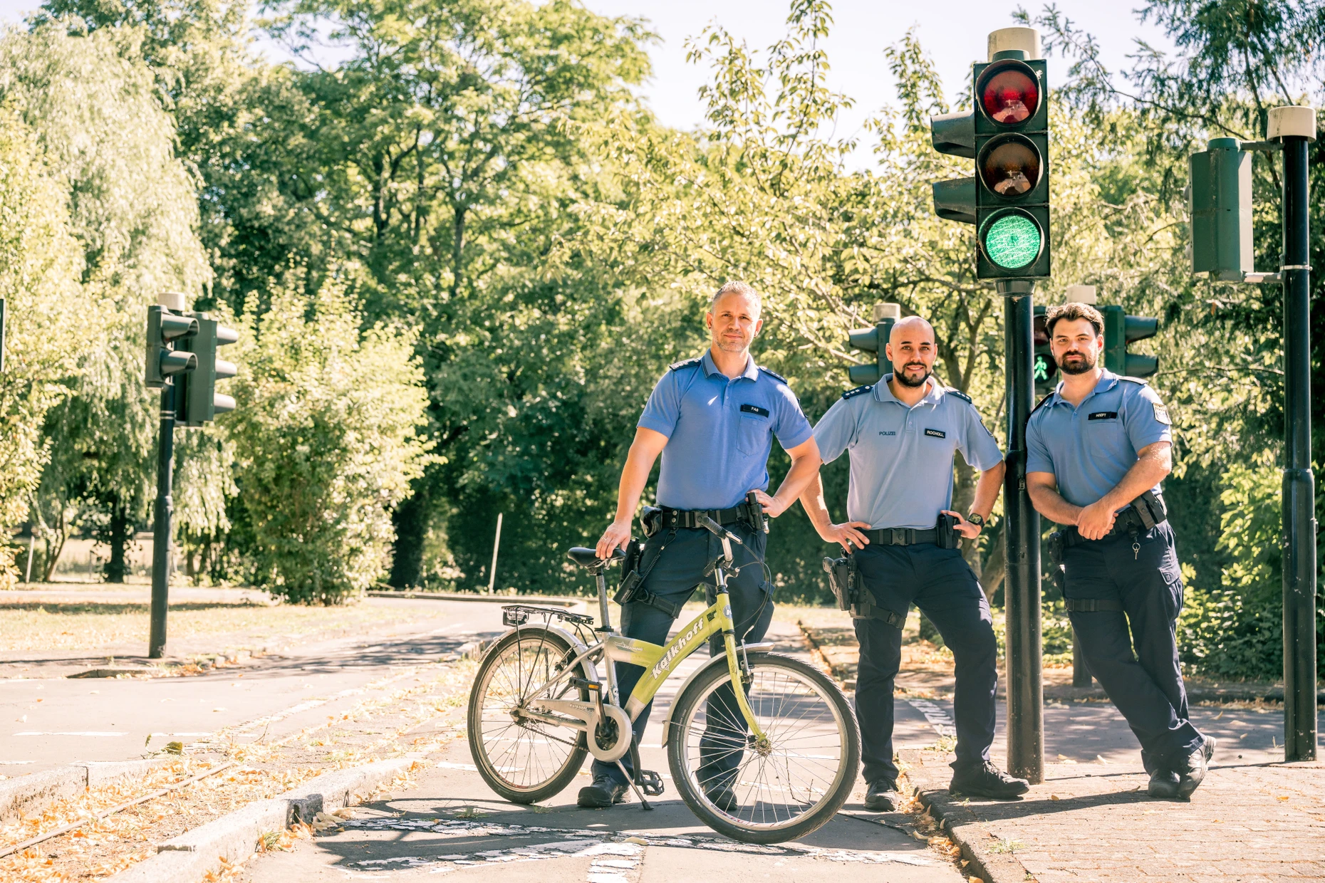 Sie zählen zum Team der Verkehrserzieher: die Polizeihauptkommissare Daniel Faß und Nicolas Rocholl sowie Polizeioberkommissar Christopher Hoeft an der Ampelkreuzung im Verkehrskindergarten.