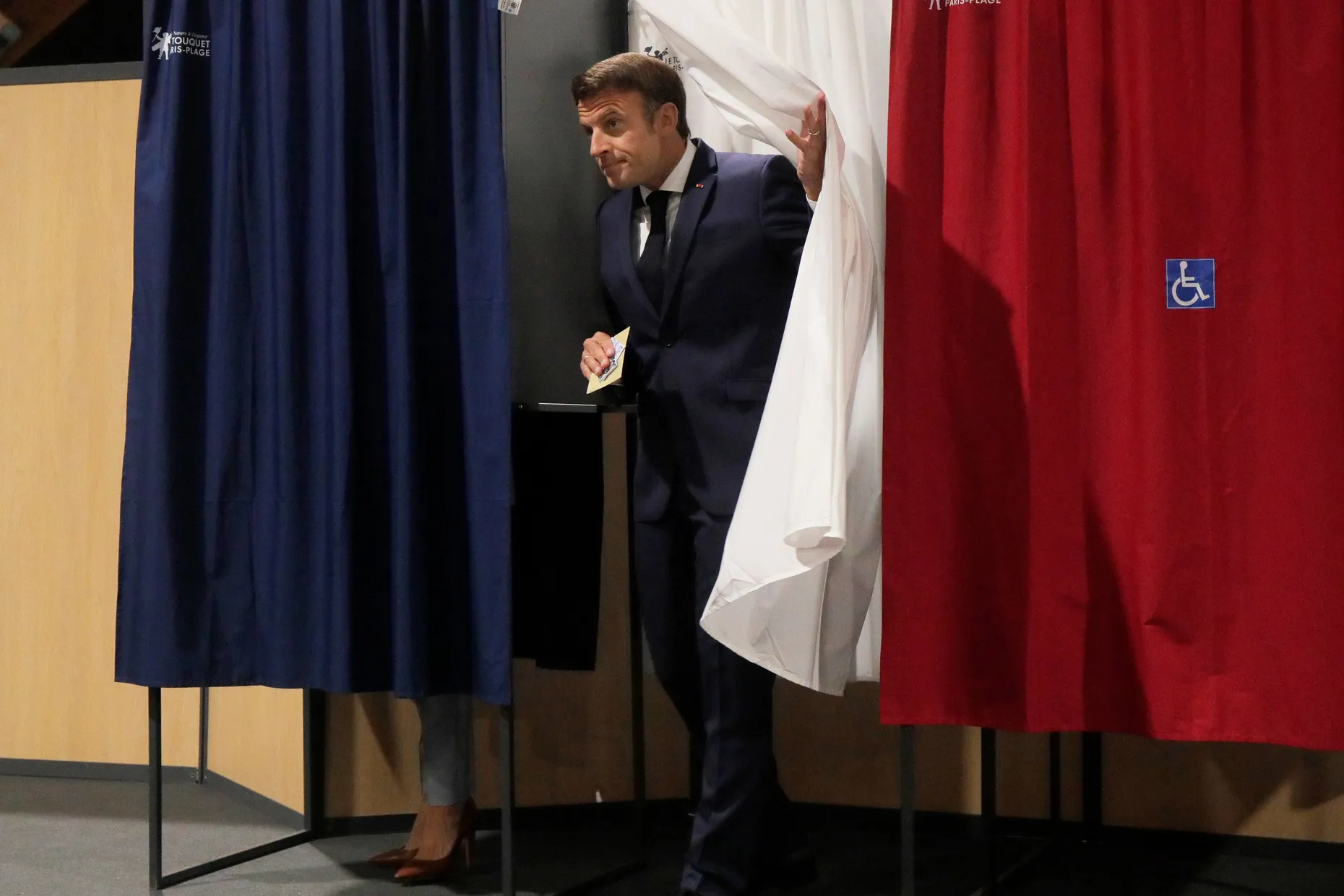 Macron verlässt die Wahlkabine.