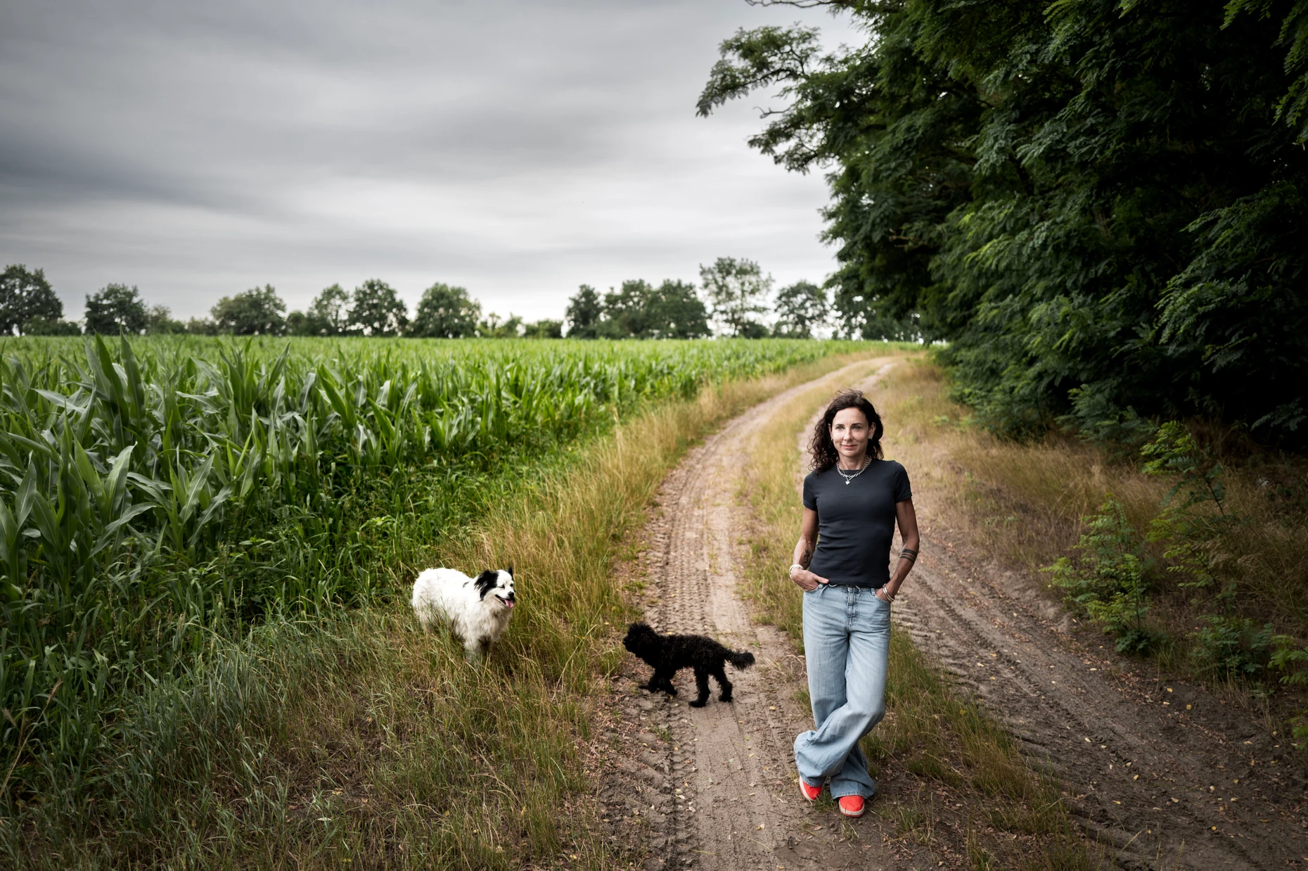 Juli Zeh mit ihren beiden Hunden auf einem Feldweg nahe ihrem Wohnort