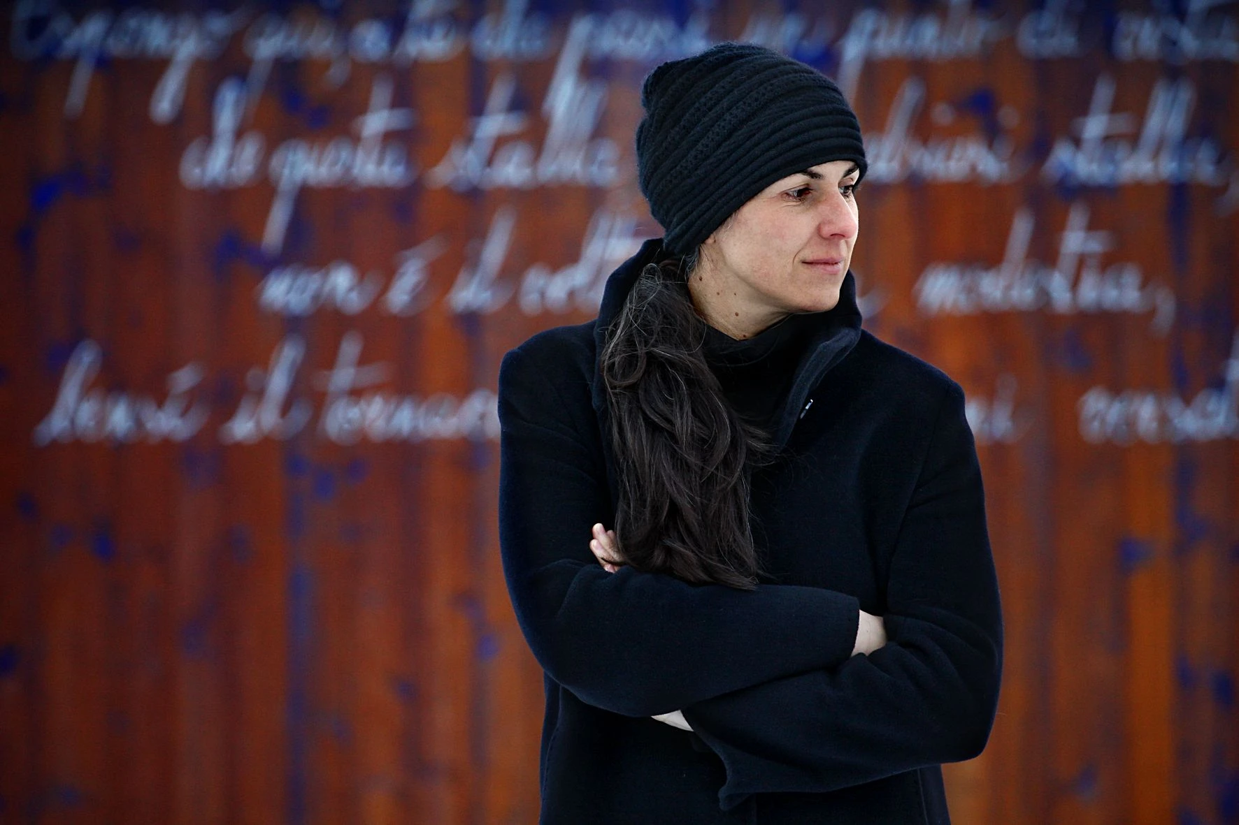 Ein Gedicht Roberta Dapunts ziert die Scheunenwand gegenüber dem Atelier ihres Mannes, des Bildhauers Lois Anvidalfarei