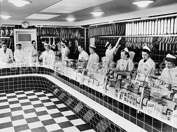 Wohlstand für alle: Mitarbeiter einer Metzgerei in Hamburg warten 1953 auf Kunden.