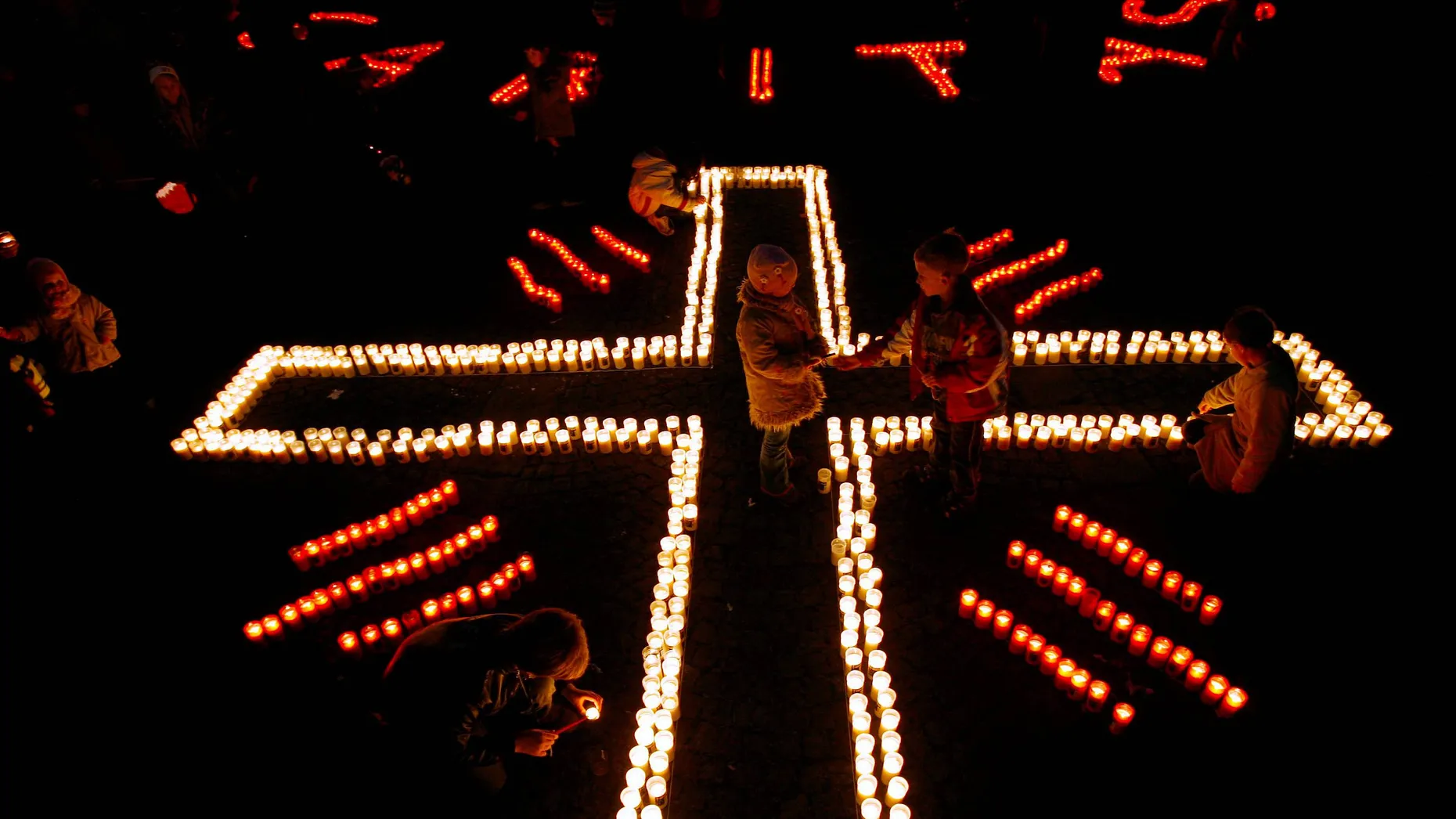 Licht und Schatten: das Caritas-Kreuz im Kerzenschein