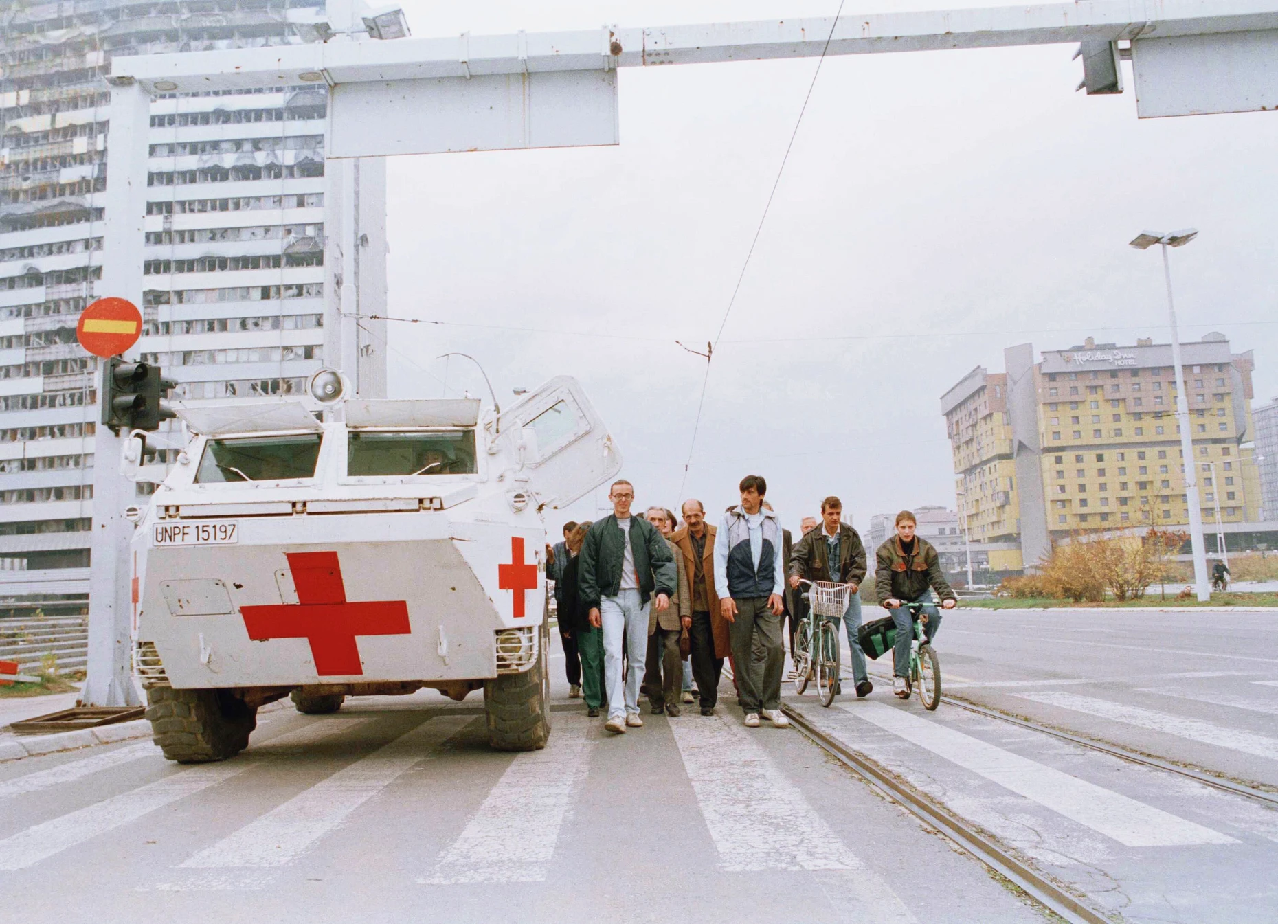 Bewohner von Sarajevo verstecken sich hinter einem gepanzerten Fahrzeug der Vereinten Nationen im November 1994, um nicht von Scharfschützen erschossen zu werden.