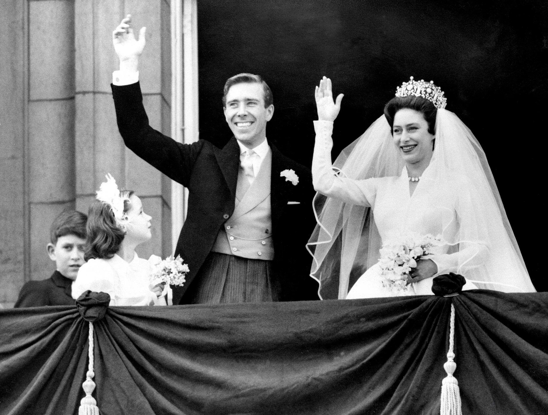 Erstmals groß im Fernsehen: Nach der Hochzeit im Mai 1960 winken Prinzessin Margaret und Anthony Armstrong-Jones, der spätere Lord Snowdon, vom Balkon des Londoner Buckingham-Palasts, links steht der kleine Neffe der Braut, der heutige Charles III.