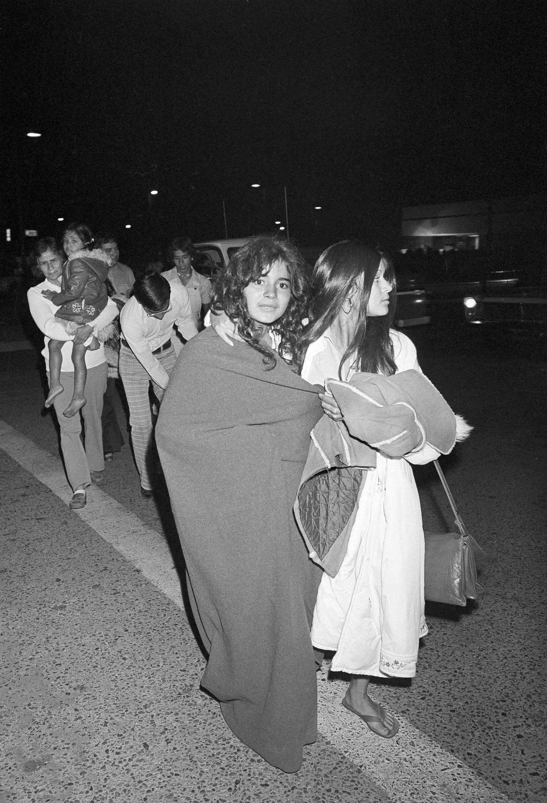 Gerettet! In Tücher gewickelt laufen zwei Schülerinnen am 17. Juli 1976 zu den Autos ihrer Eltern, nachdem sie am Morgen wieder nach Chowchilla zurückgebracht worden waren. 26 Schüler und ein Busfahrer waren am 15. Juli entführt worden und in einem Steinbruch, der elf Stunden Autofahrt entfernt lag, unter der Erde gefangen gehalten worden.