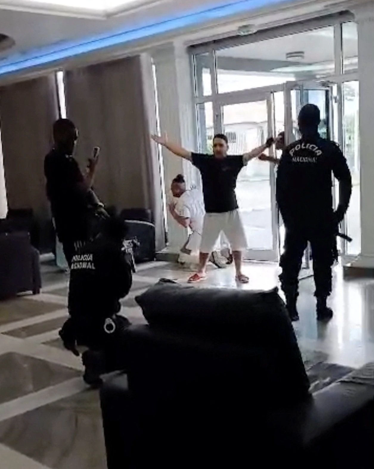 Ein Foto der Nachrichtenagentur Reuters, auf dem zu sehen ist, wie ein Sicherheitsmann in dem Hotel in Malabo die Waffe auf einen Mann richtet.