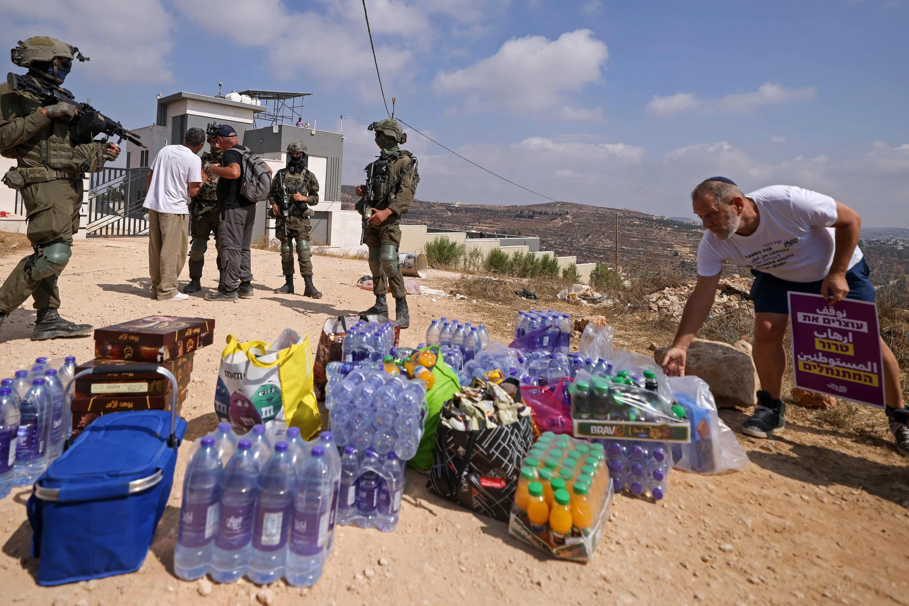 Israelische Soldaten und Aktivisten mit Hilfslieferungen am 14. August in Qusra