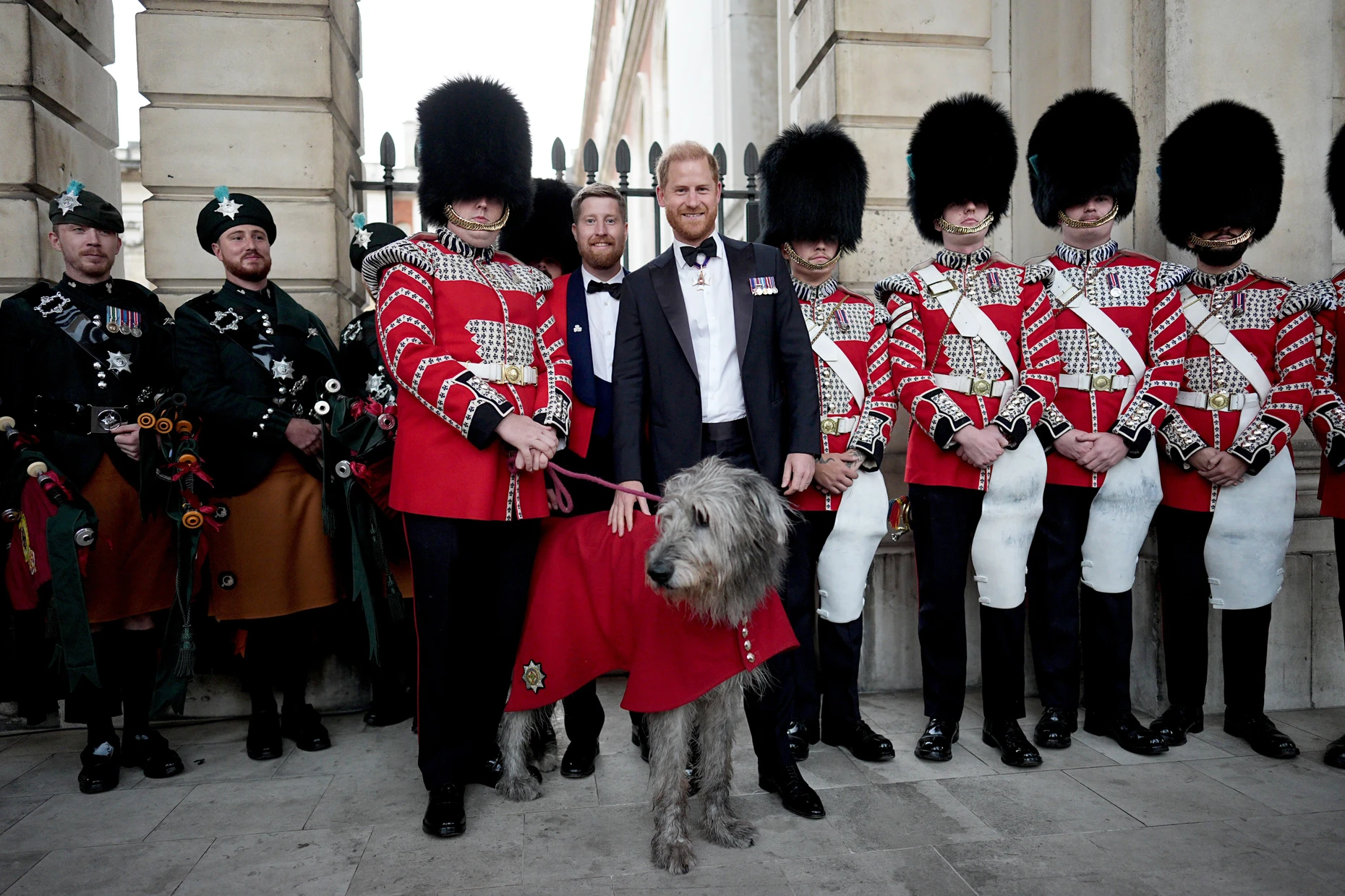 Mit Maskottchen: Prinz Harry wird von Mitgliedern der Band of The Irish Guards in die Mitte genommen.