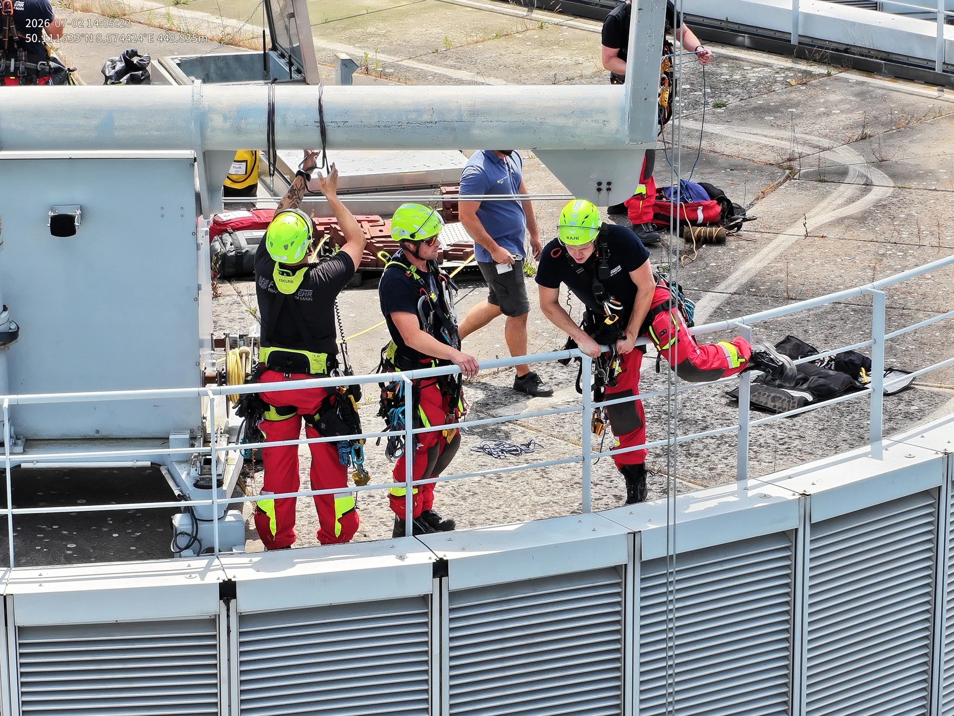 Drohnenaufnahme: Ein Höhenretter der Frankfurter Feuerwehr zieht einen Fassadenreiniger auf dem Commerzbank-Turm nach oben.
