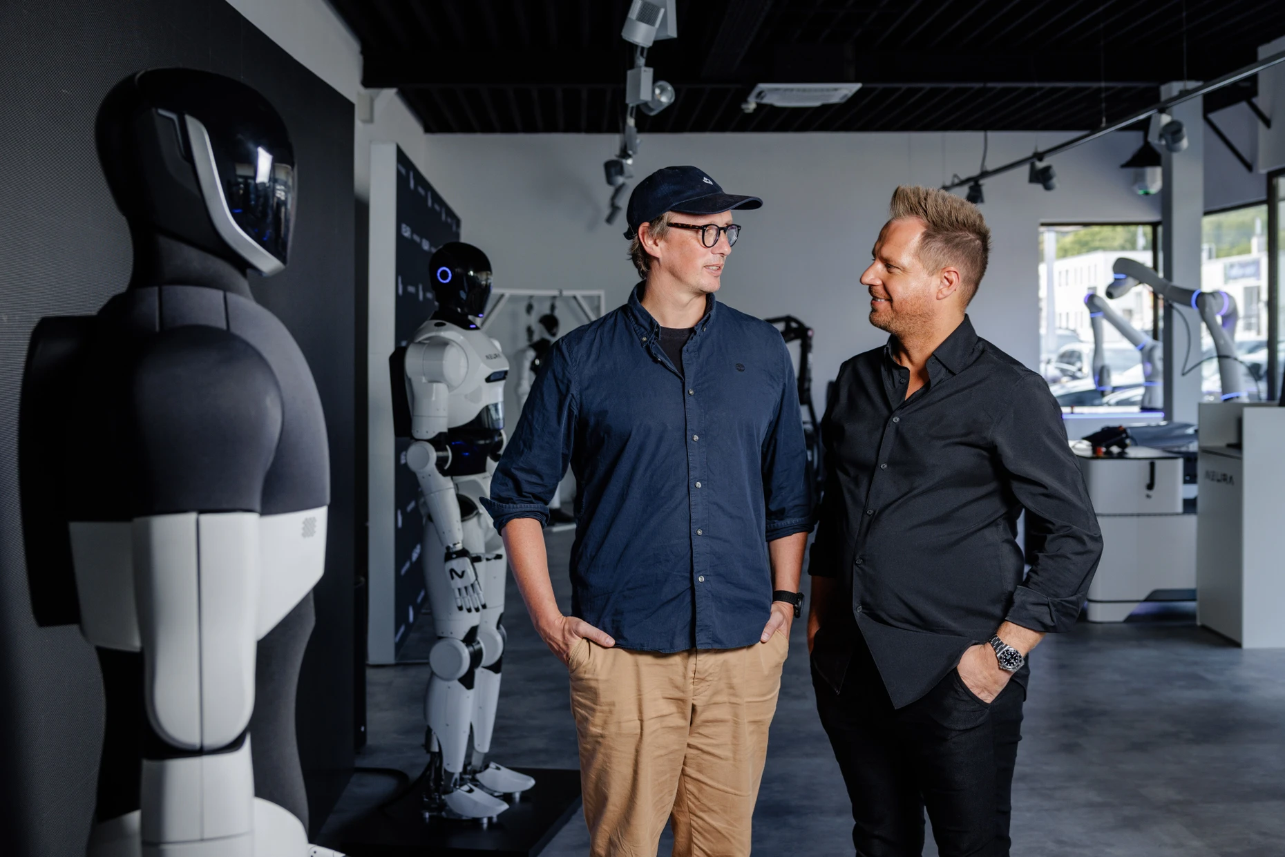 Investor Herbert Mangesius (links) und Neura-Chef David Reger neben den humanoiden Robotern.