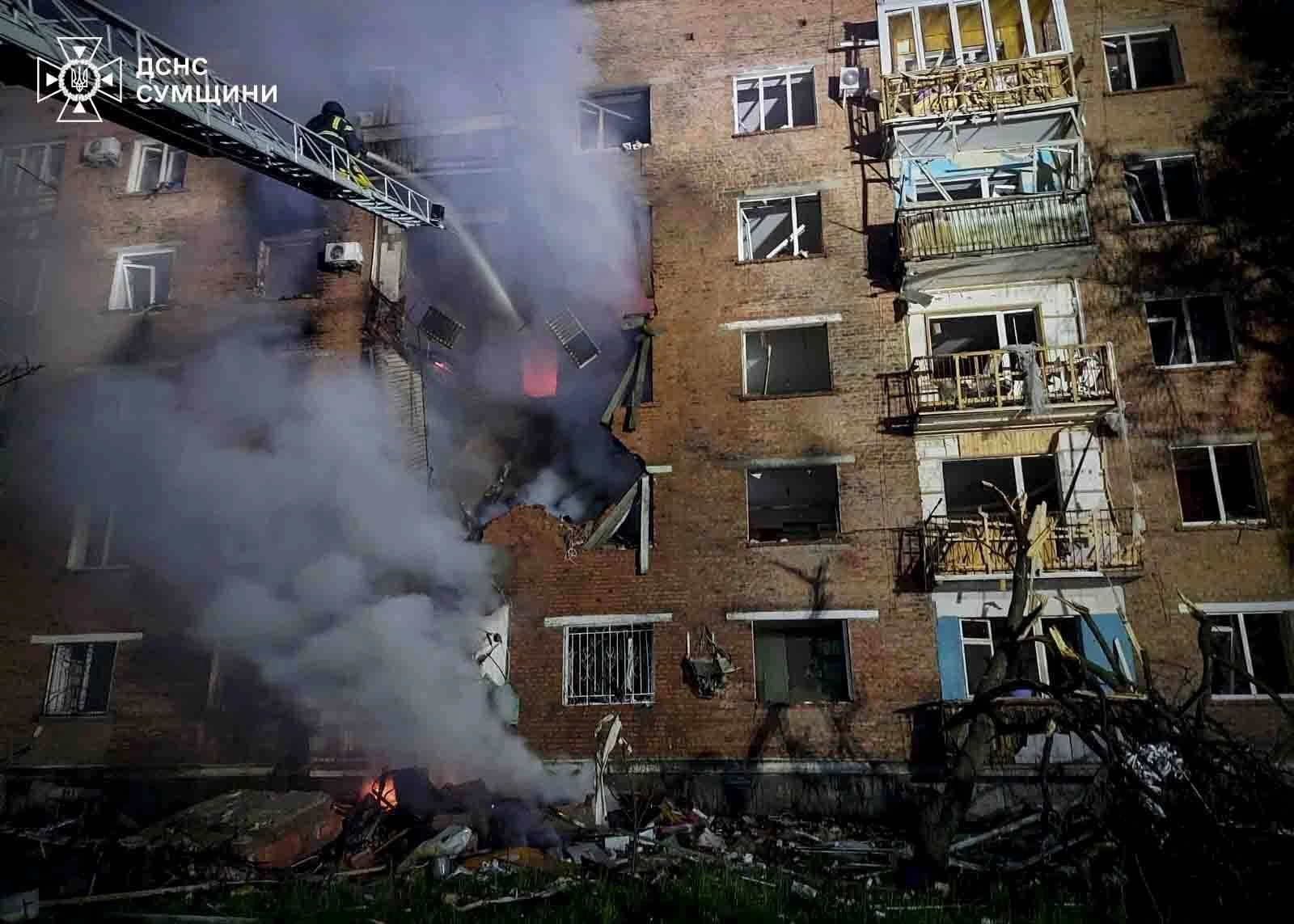 Ukraine, Konotop: Rettungskräfte löschen nach einem russischen Angriff ein Feuer in einem Wohnhaus.