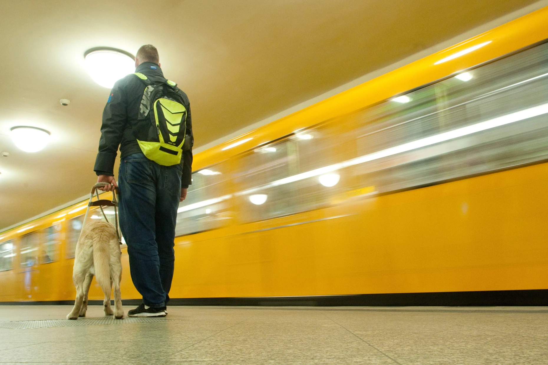 Tierischer Halt: Mann mit Blindenführhund auf einem U-Bahnsteig in Berlin