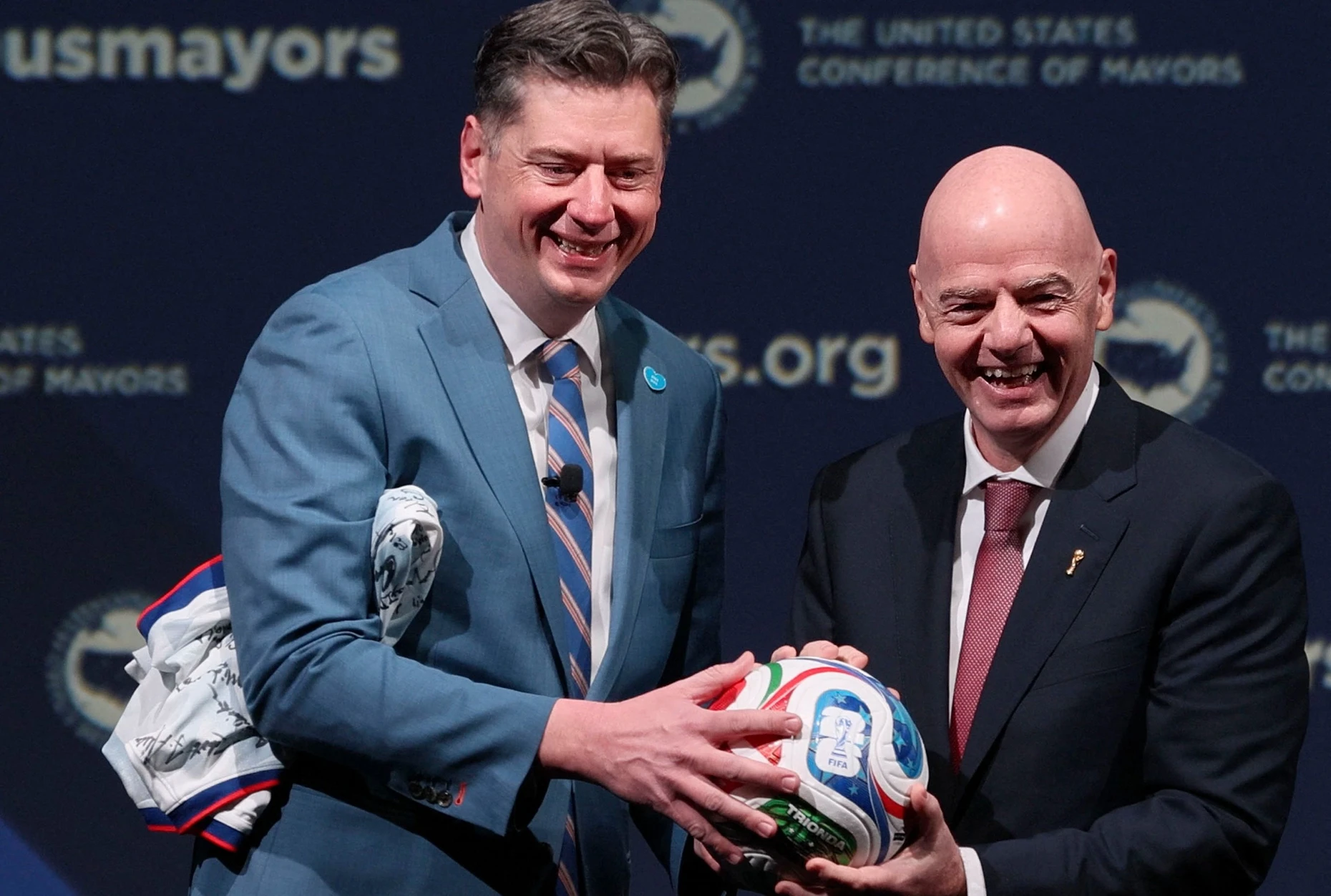 Für alle da: Holt, Präsident der United States Conference of Mayors, nimmt im Januar 2026 in Washington den offiziellen FIFA-Weltmeisterschaftsball von FIFA-Präsident Gianni Infantino entgegen.