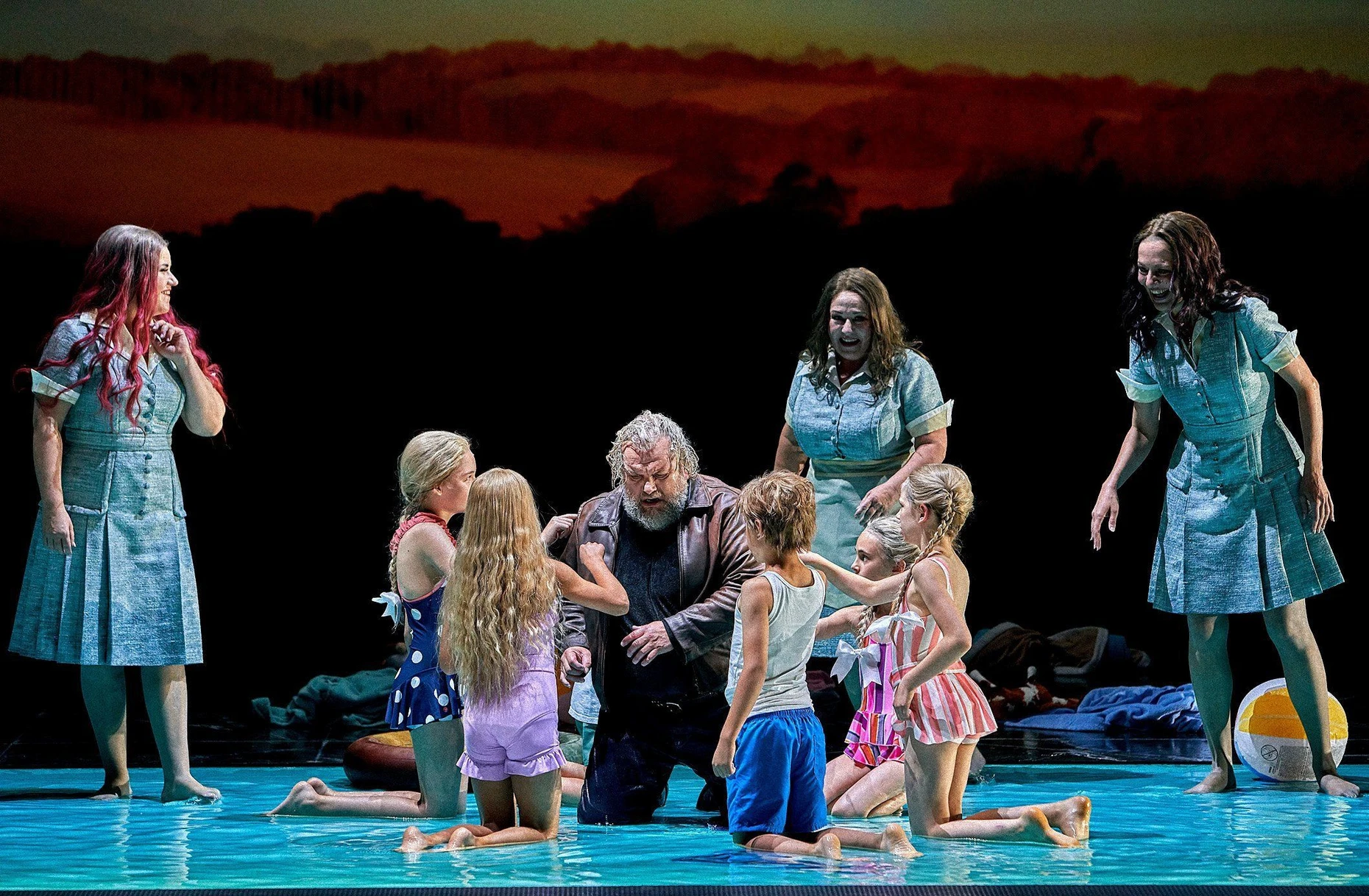 Evelin Novak (Woglinde, l.), Olafur Sigurdarson (M., Alberich), Simone Schröder (Floßhilde, 4. v. r.), Stephanie Houtzeel (Wellgunde, r.) und Schülerstatisten der Bayreuther Festspiele in Valentin Schwarz’ Inszenierung des „Rheingolds“ 2023