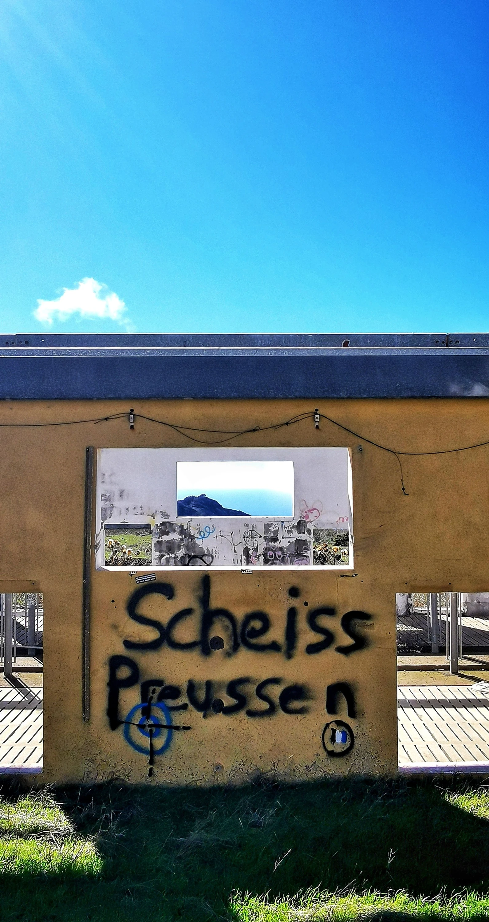 Die Ruine einer Schweinefarm mit deutschem Graffiti.
