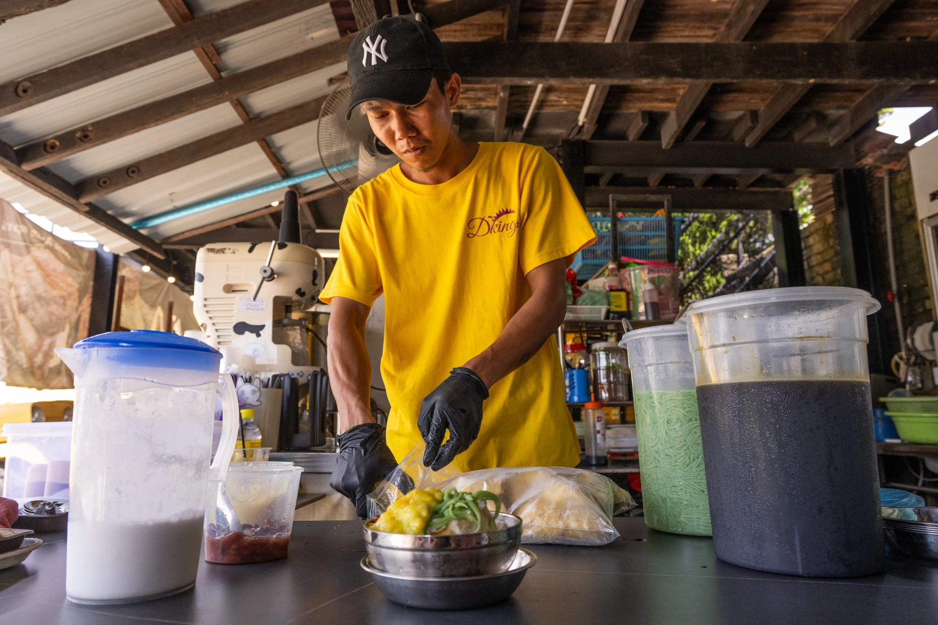 An einem Imbissstand in Karak bereitet ein Verkäufer Durian-Cendol zu. Cendol ist ein südostasiatisches Dessert mit grünen Geleestreifen aus Reismehl und Pandan.
