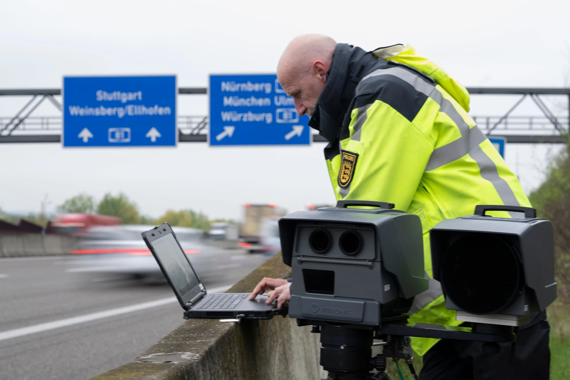 Eine mobile Geschwindigkeitsmessanlage der Autobahnpolizei Weinsberg wird am Rand der A6 von einem Polizeibeamten eingerichtet. Aufnahme von April 2026.