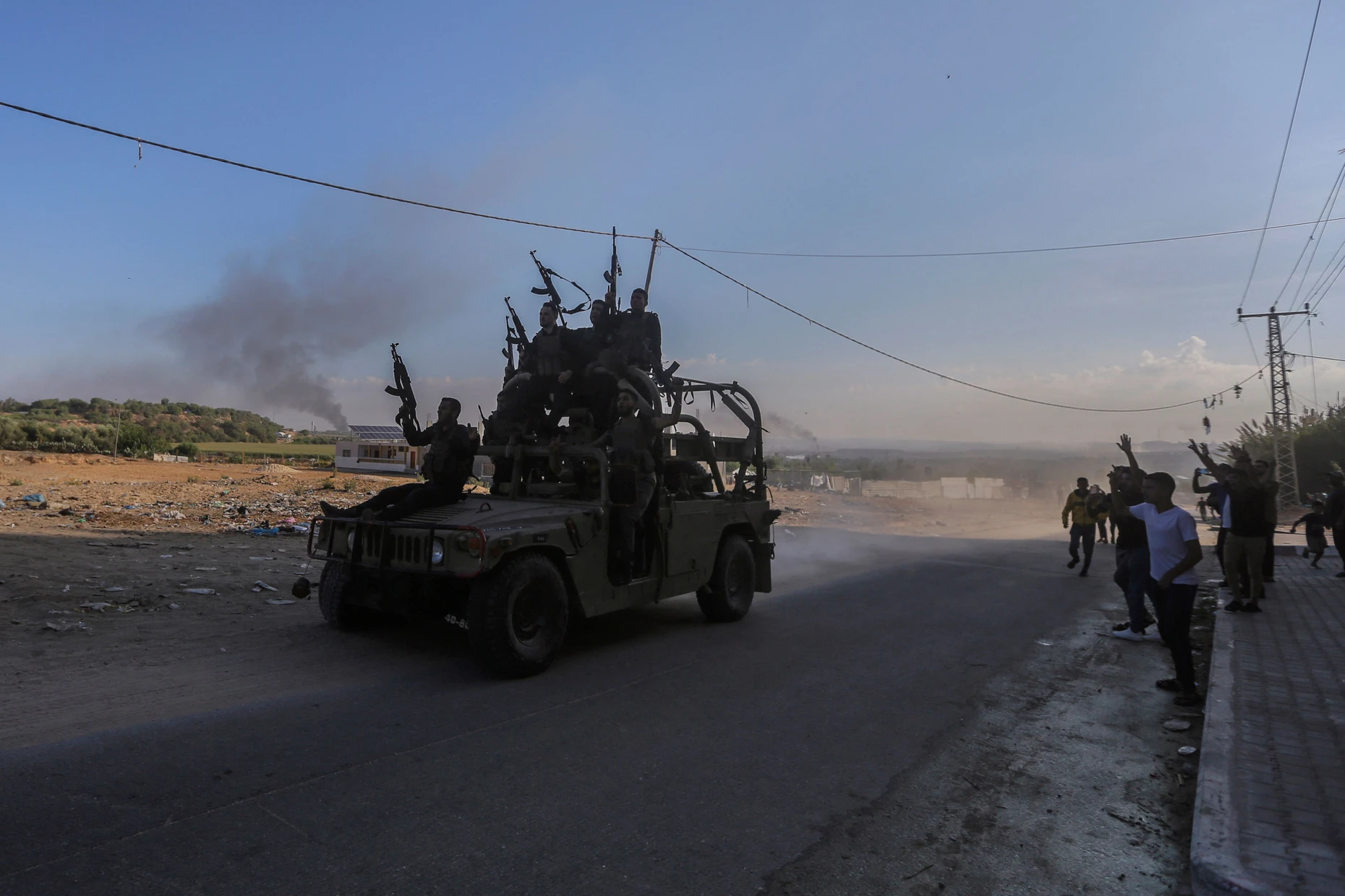 Hamas-Kämpfer fahren in einem erbeuteten israelischen Militärfahrzeug durch die Straßen von Gaza.