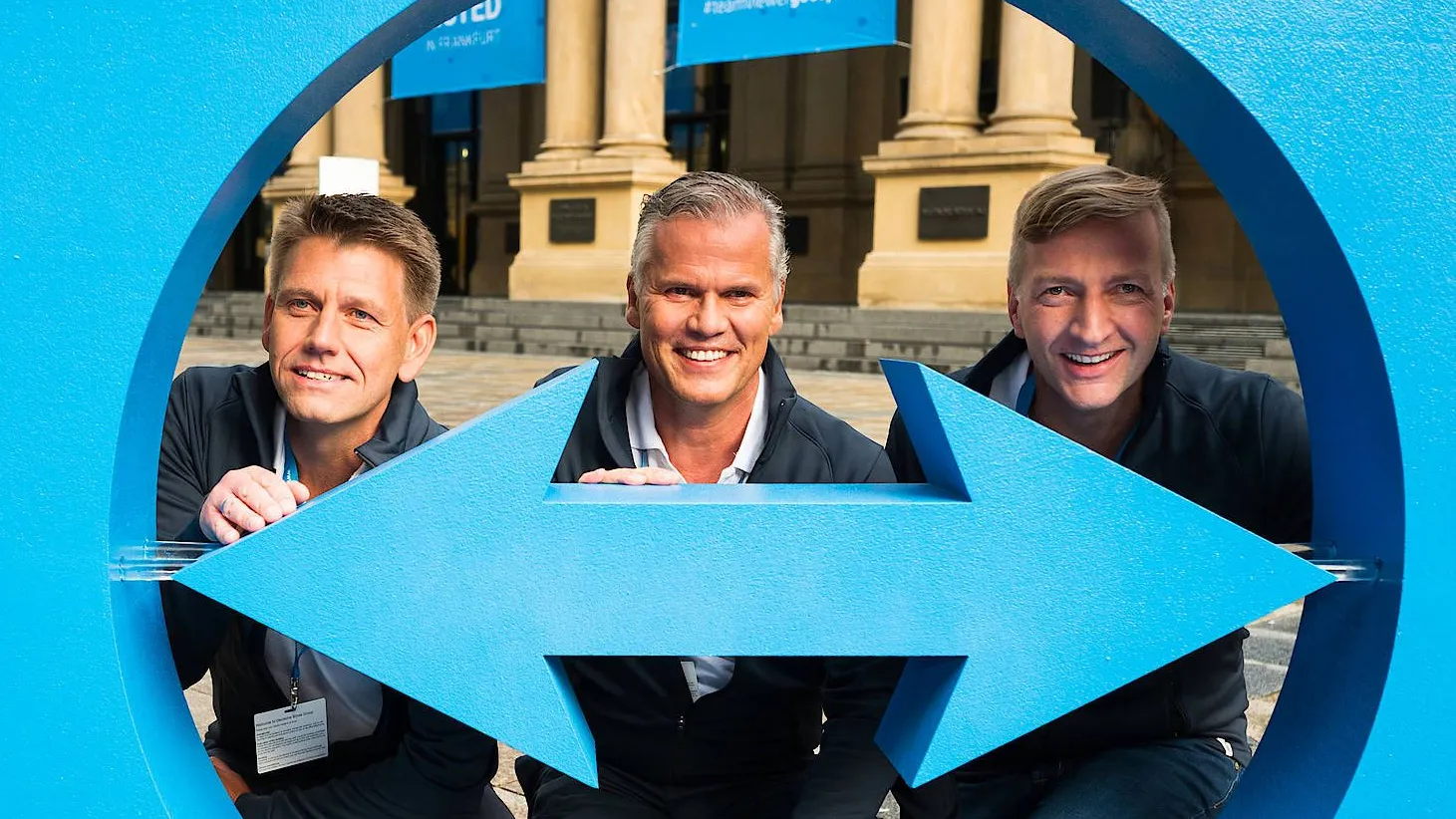 Von links: Oliver Steil, Vorstandsvorsitzender von Teamviewer, Jörg Rockenhäuser, Deutschland-Chef von Investor Permira, und Stefan Gaiser, Finanzvorstand von Teamviewer, blicken am Tag des Börsengangs durch das blaue Logo des Unternehmens.