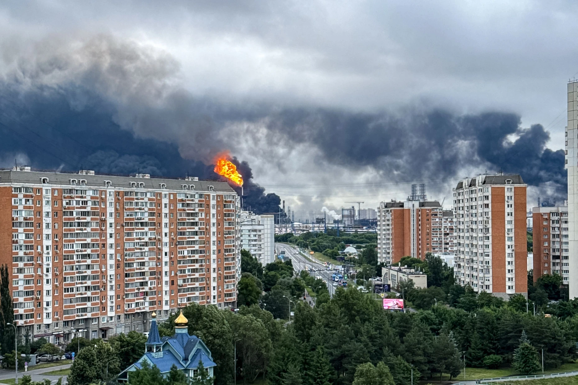 Wohnblocks in Moskau, im Hintergrund brennt die Ölraffinerie