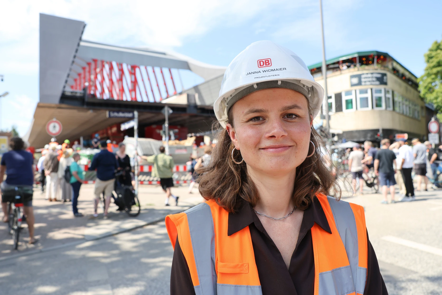 Projektleiterin Janna Widmaier von DB InfraGO steht vor der Baustelle mit dem Rohbau der neuen Sternbrücke, eine 108 Meter lange und 21 Meter breite, stützenfreie Stabbogenkonstruktion.
