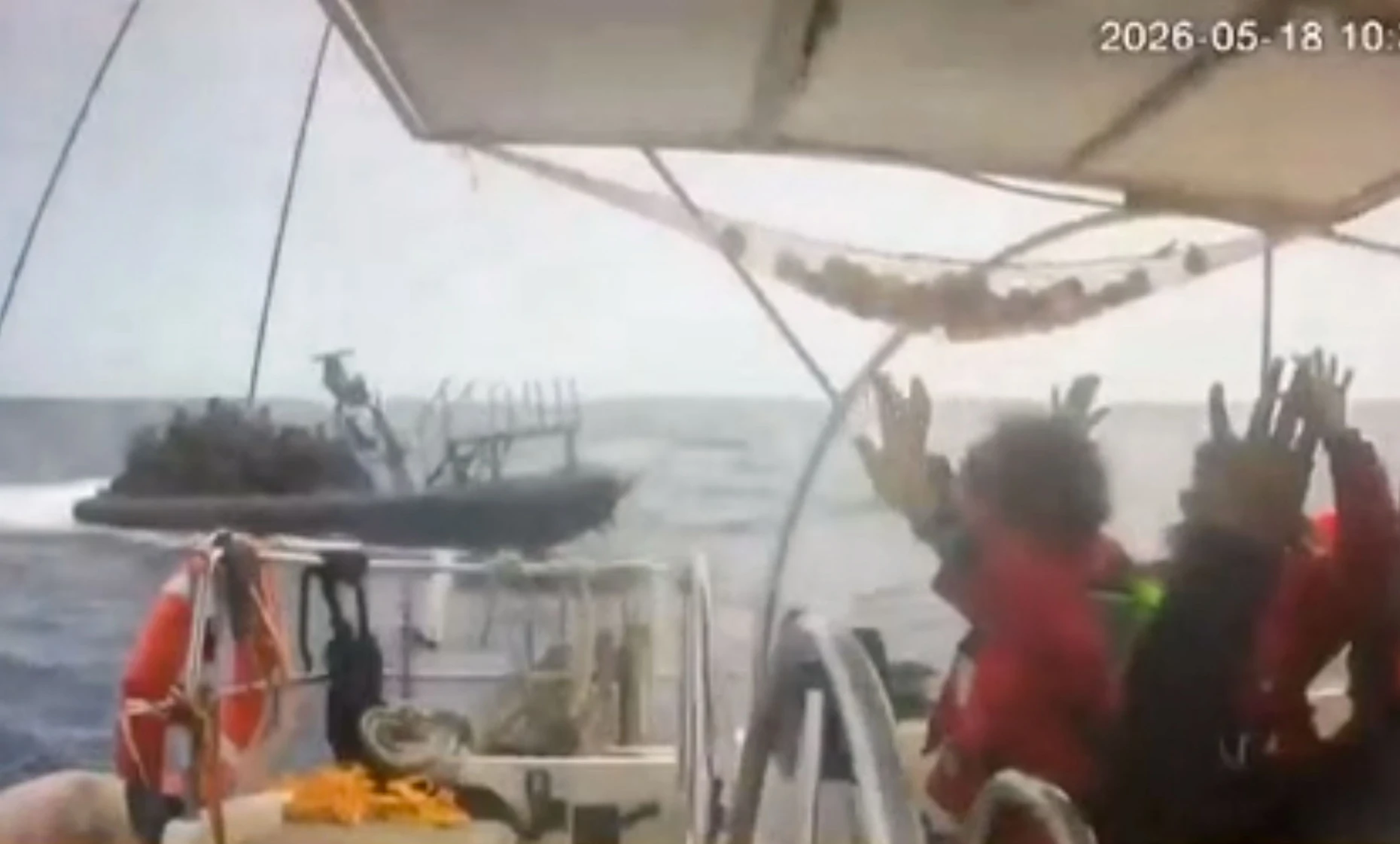 Dieses Videostandbild aus Überwachungsaufnahmen vom 18.5.26 zeigt Aktivisten an Bord der „Global Sumud Flotilla“, die ihre Hände in die Luft heben, während sich ein Boot nähert.