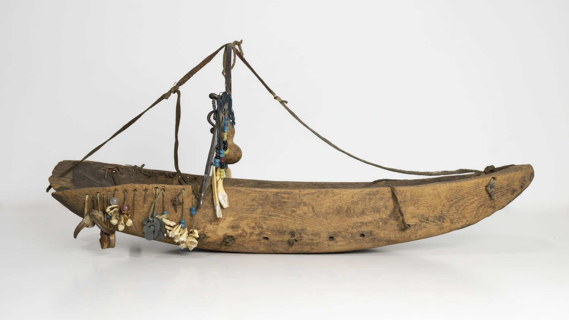 Die mit Amuletten verzierte Kinderwiege der Nanai aus Holz, Rinde und Fischhaut soll fragile Seelen im Körper zurückhalten.