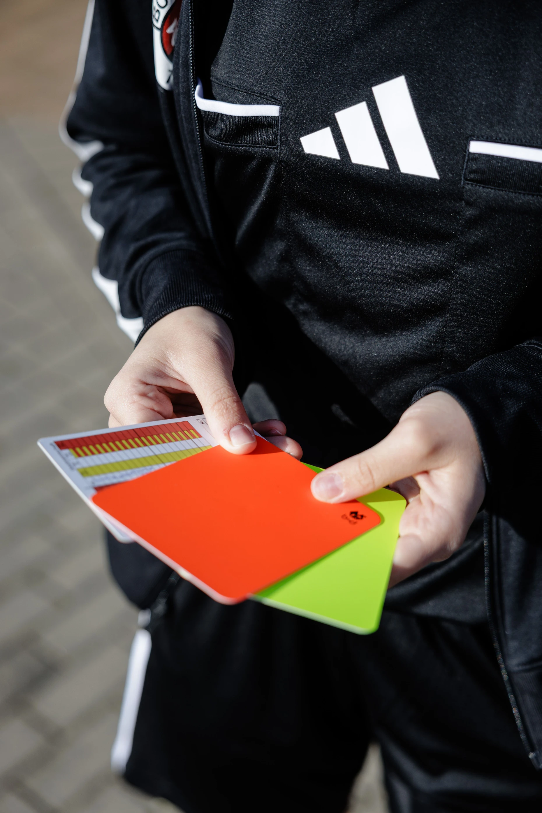 Ihre Gelbe und Rote Karte und die Spielnotizkarte bewahrt Dana in der Brusttasche auf.