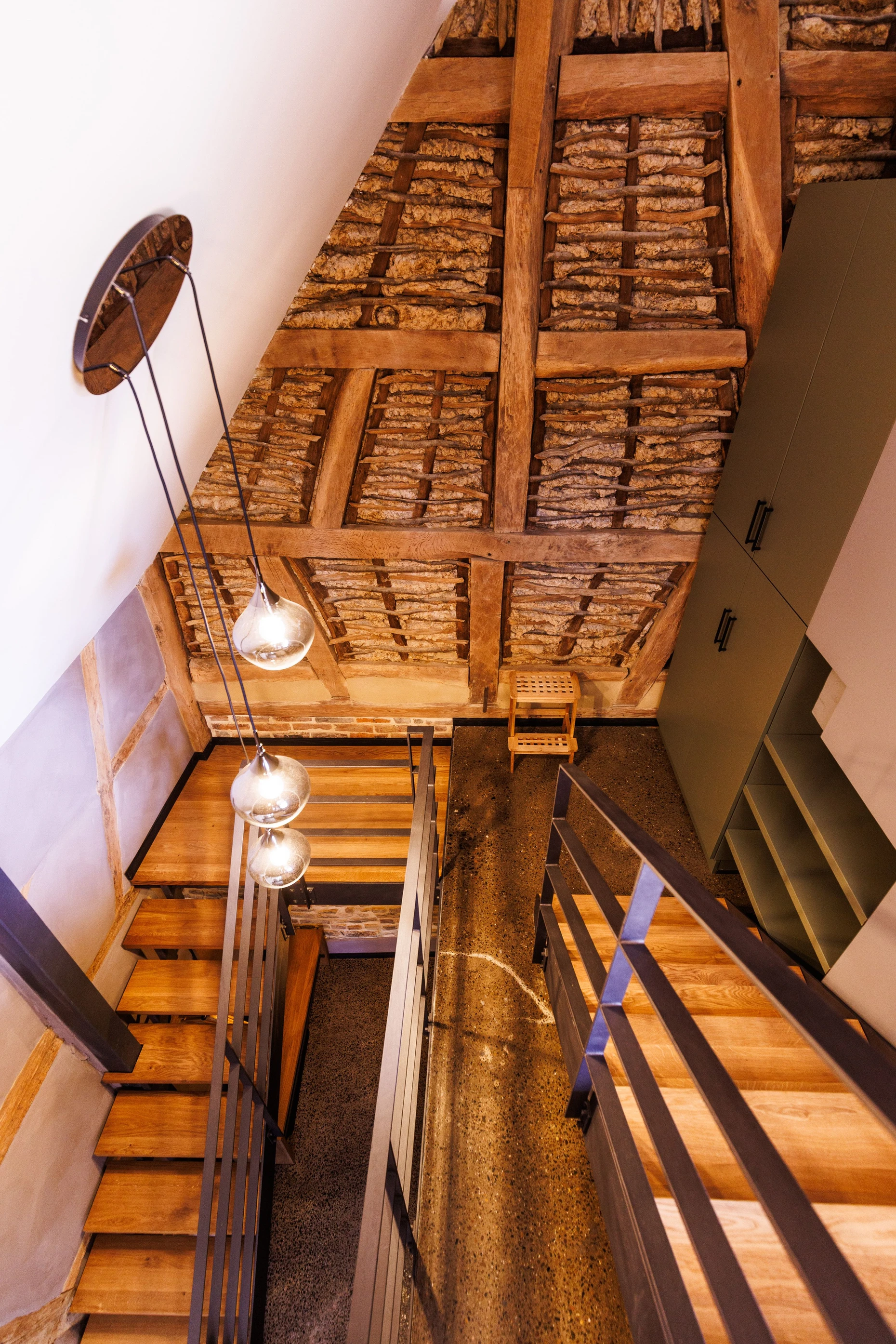 Lehm und Stahl vertragen sich gut: Hinter der modernen Treppe in der Scheune ist die Konstruktion freigelegt.
