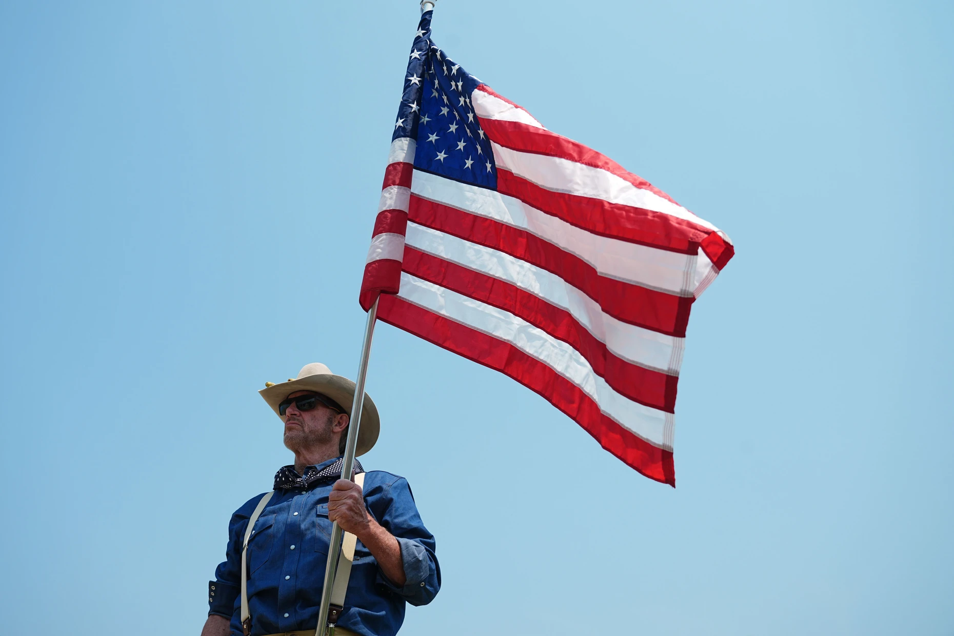 Ein Mann, der als Roughrider kostümiert ist, wartet am 1. Juli 2026 auf die Ankunft Donald Trumps in Medora. Die Roughrider waren im Amerikanisch-Spanischen Krieg ein Freiwilligen-Kavallerieregiment.