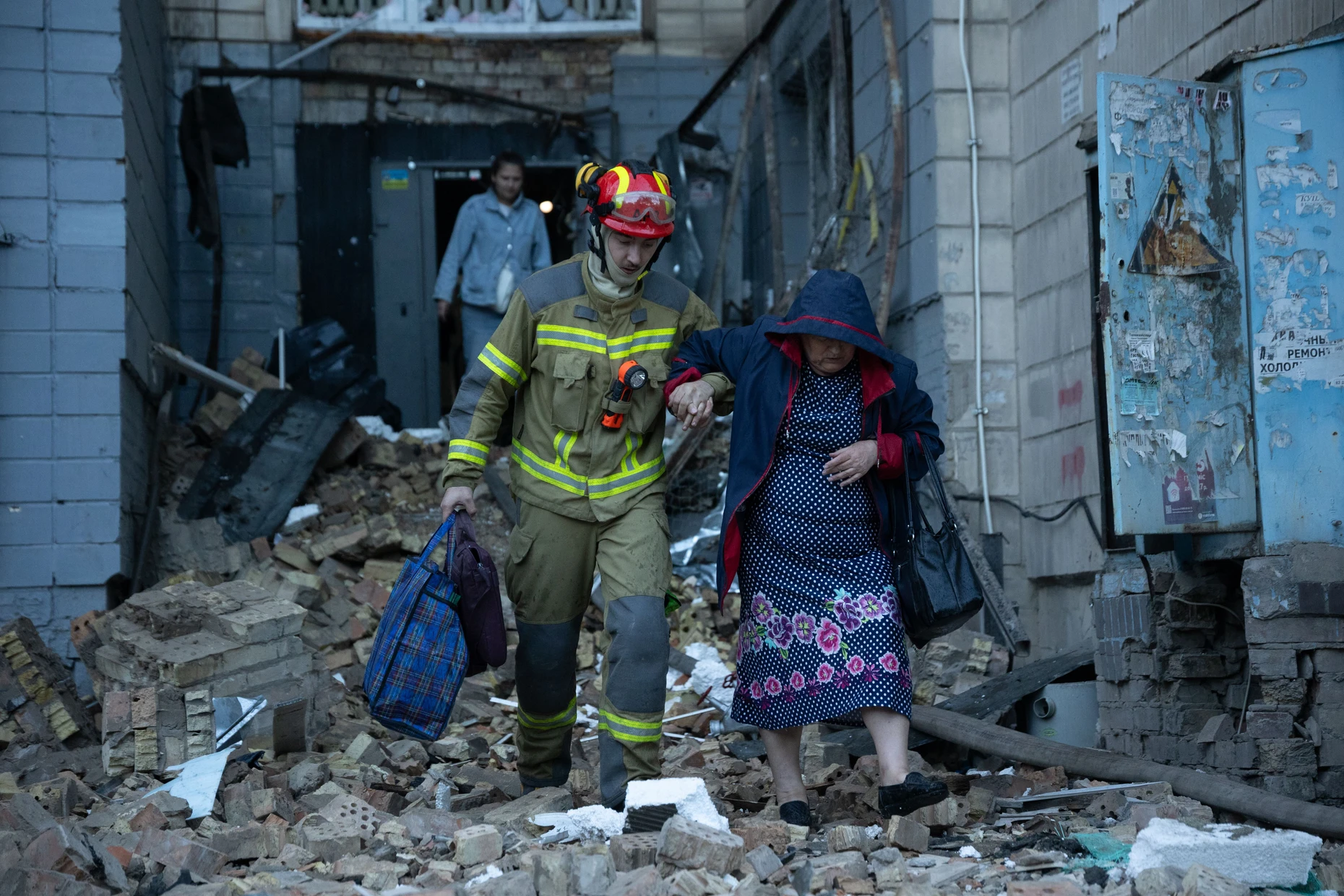 Ein Feuerwehrmann hilft einer älteren Frau.