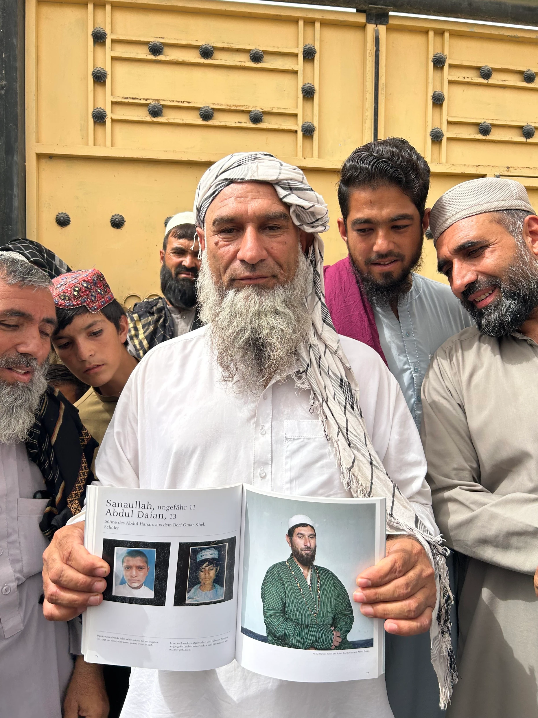 Abdul Hanan zeigt einen Fotoband der deutschen Journalisten Christoph Reuter und Marcel Mettelsiefen, in dem auch seine beiden bei dem deutschen Angriff getöteten Söhne abgebildet sind.