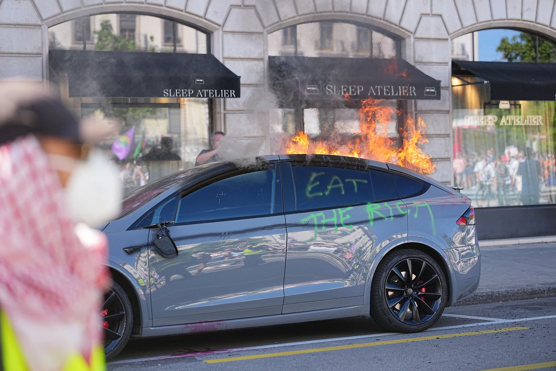 Am Rande der Proteste brennt ein Tesla-Fahrzeug.