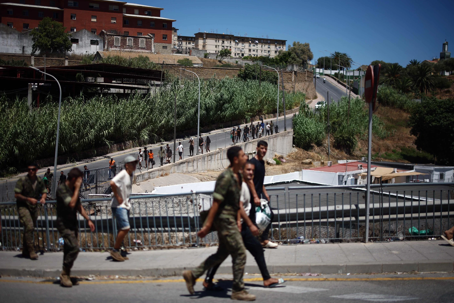 Marokkanische Migranten werden von spanischen Soldaten in Ceuta zu ihrer Abschiebung eskortiert.