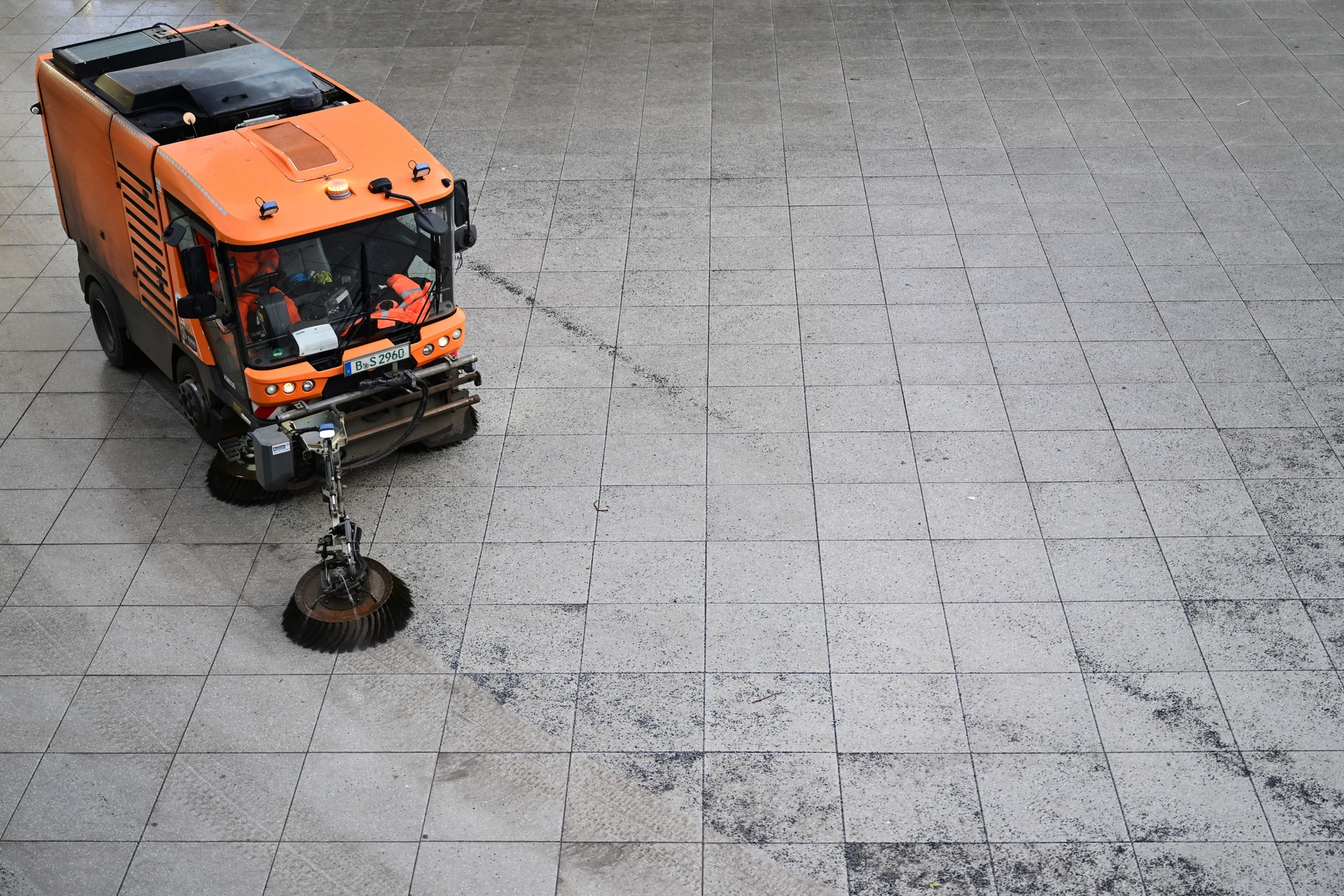 Zentraler Würdenträger der Stadt: Eine BSR-Straßenkehrmaschine fegt am Alexanderplatz Splitt auf.