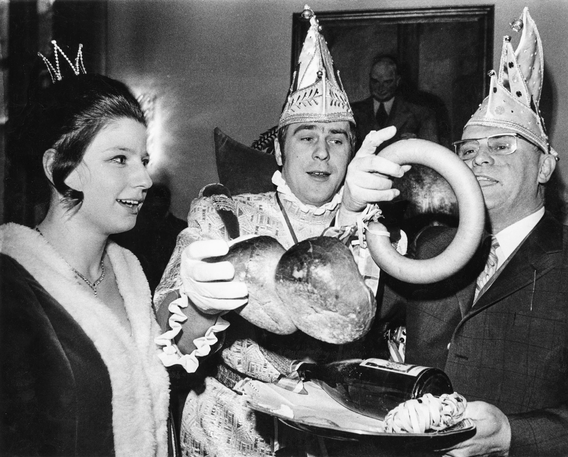 Mit Weck, Worscht un Woi: Das Frankfurter Prinzenpaar Uschi und Michael II.  überreichen die närrischen Insignien, wohl eher bekannt aus der Mainzer Fastnacht, an Oberbürgermeister Walter Möller (rechts) beim Narrenempfang im Frankfurter Römer. 3. Januar 1971
